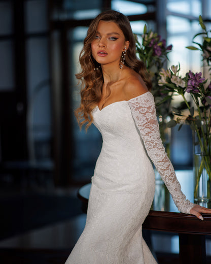 Off the shoulder lace mermaid wedding dress with long sleeves.