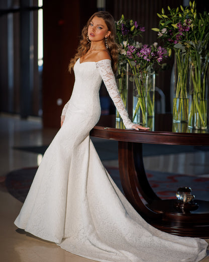Off the shoulder lace mermaid wedding dress with long sleeves.