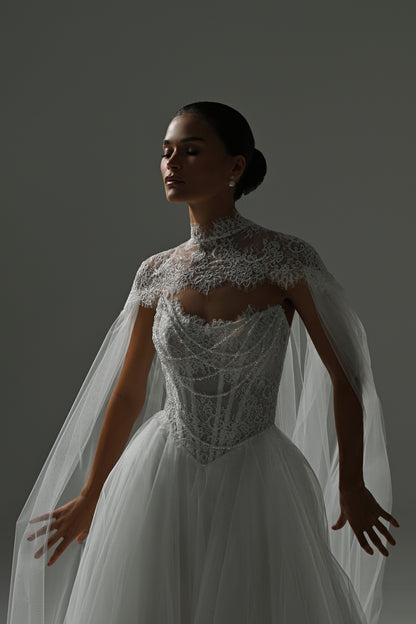 Tulle wedding dress with sheer cape – close-up of the lace corset with the cape spread to the sides