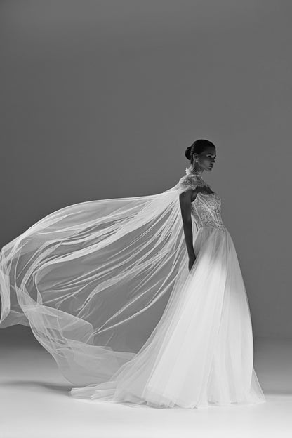 Tulle wedding dress with sheer cape – the long cape billowing out to the side