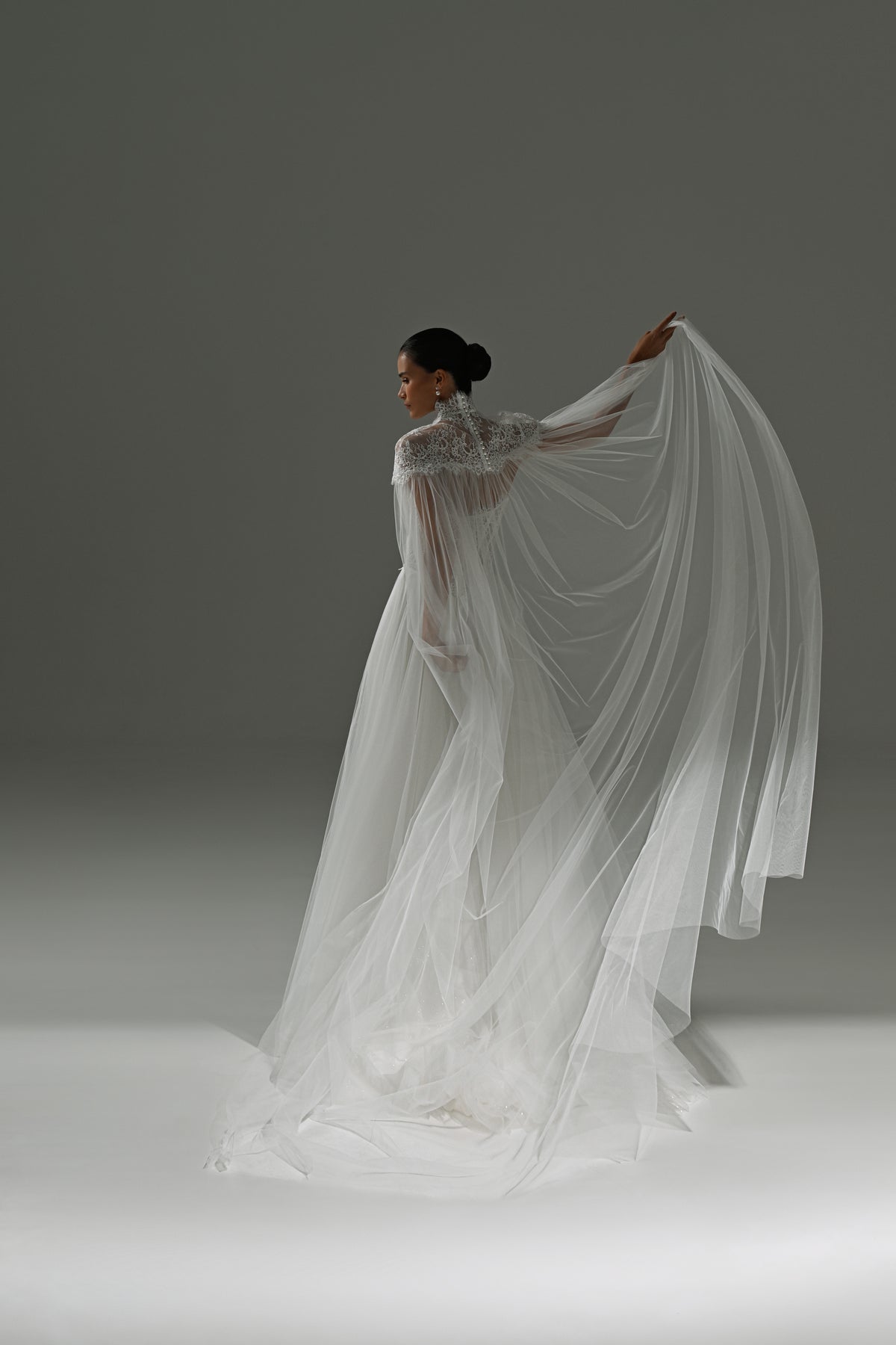 Tulle wedding dress with sheer cape – back three-quarter view with the cape raised