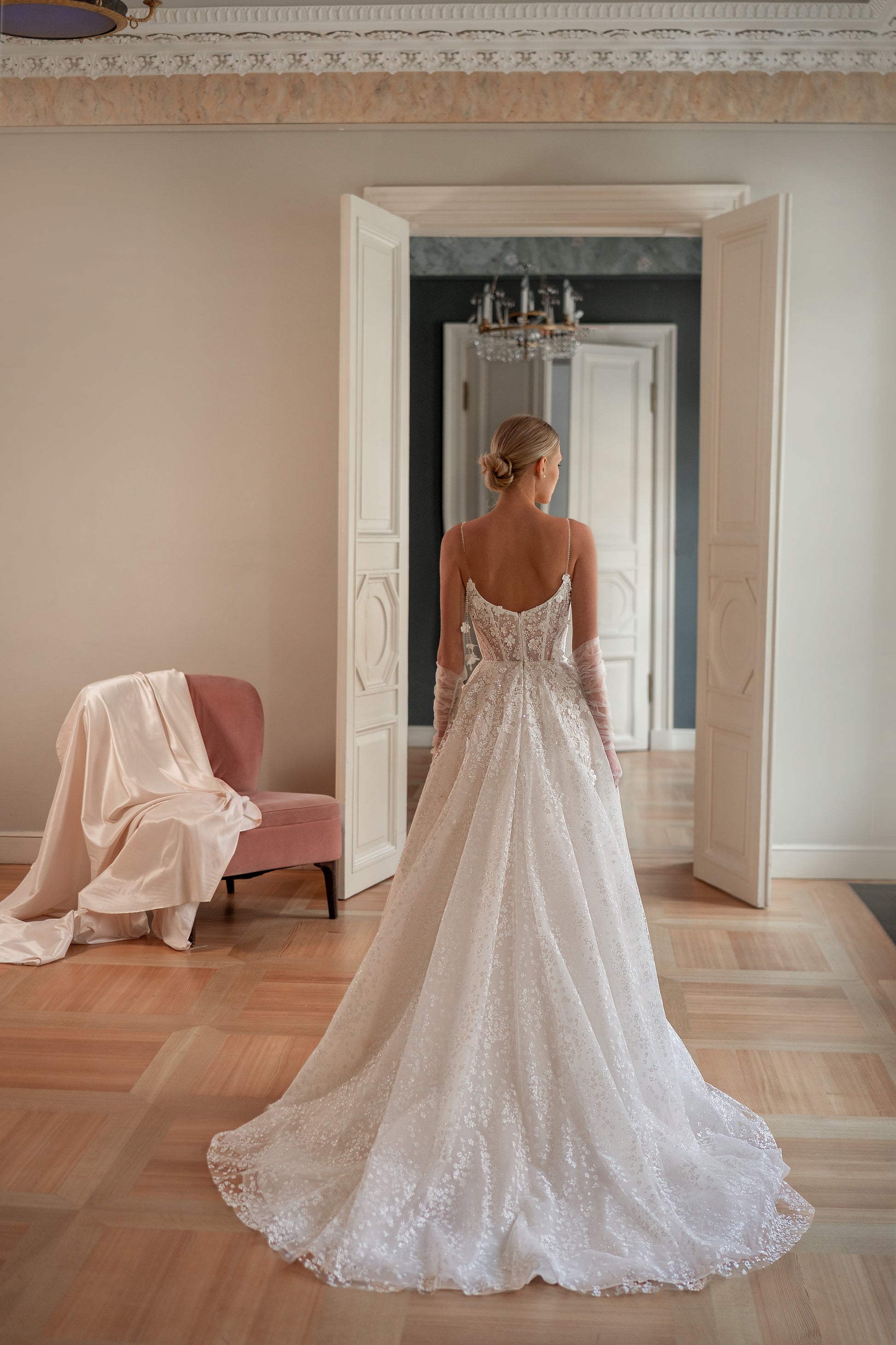 Elegant wedding dress with a glitter lace bodice, thin spaghetti straps, and flowing A-line silhouette