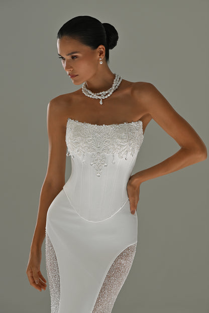 Satin mermaid wedding dress with strapless corset – close-up of the bodice and lace side panel, hand on hip