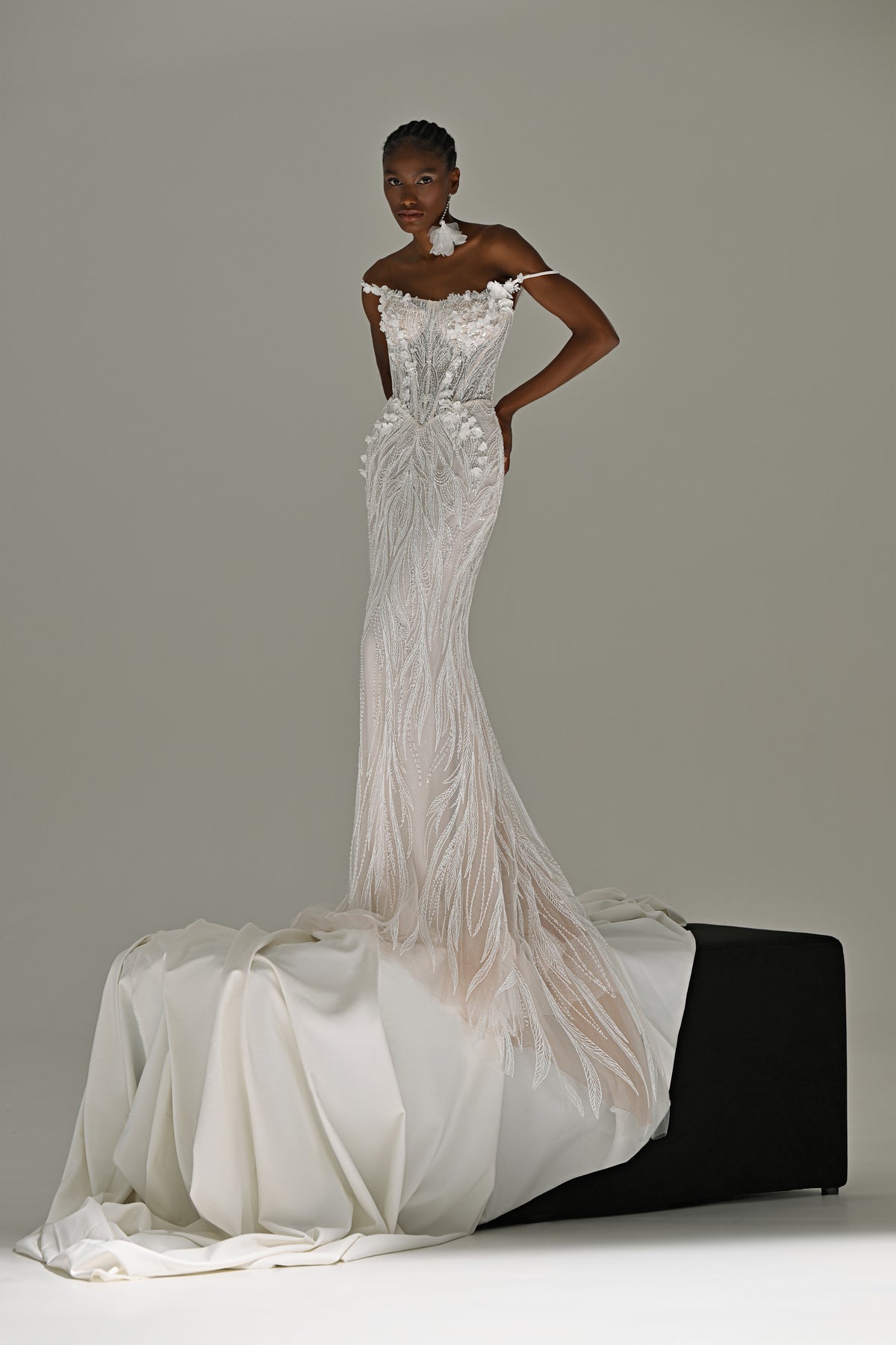 Lace mermaid wedding dress with fringe detail – standing front view, hand on hip, train over the block