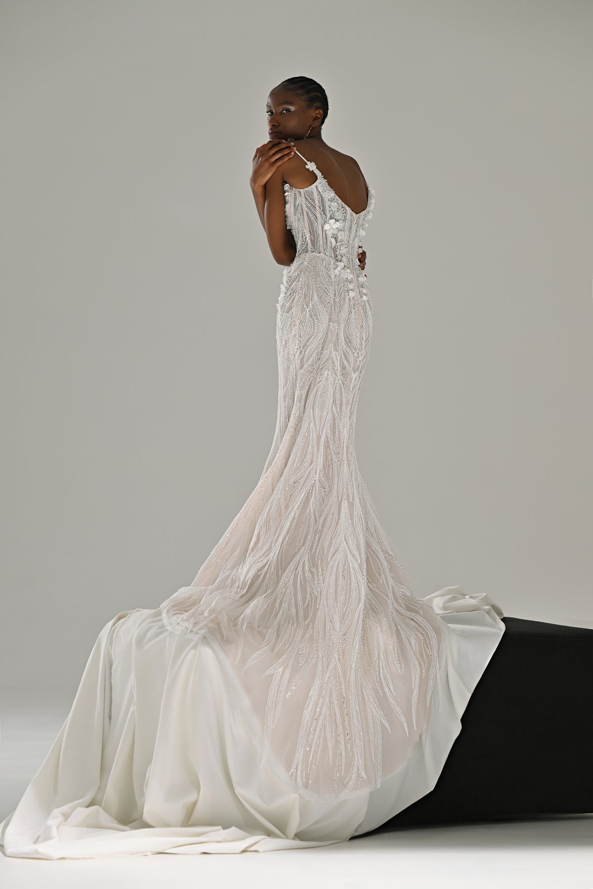 Lace mermaid wedding dress with fringe detail – front view with the train spread over a black block