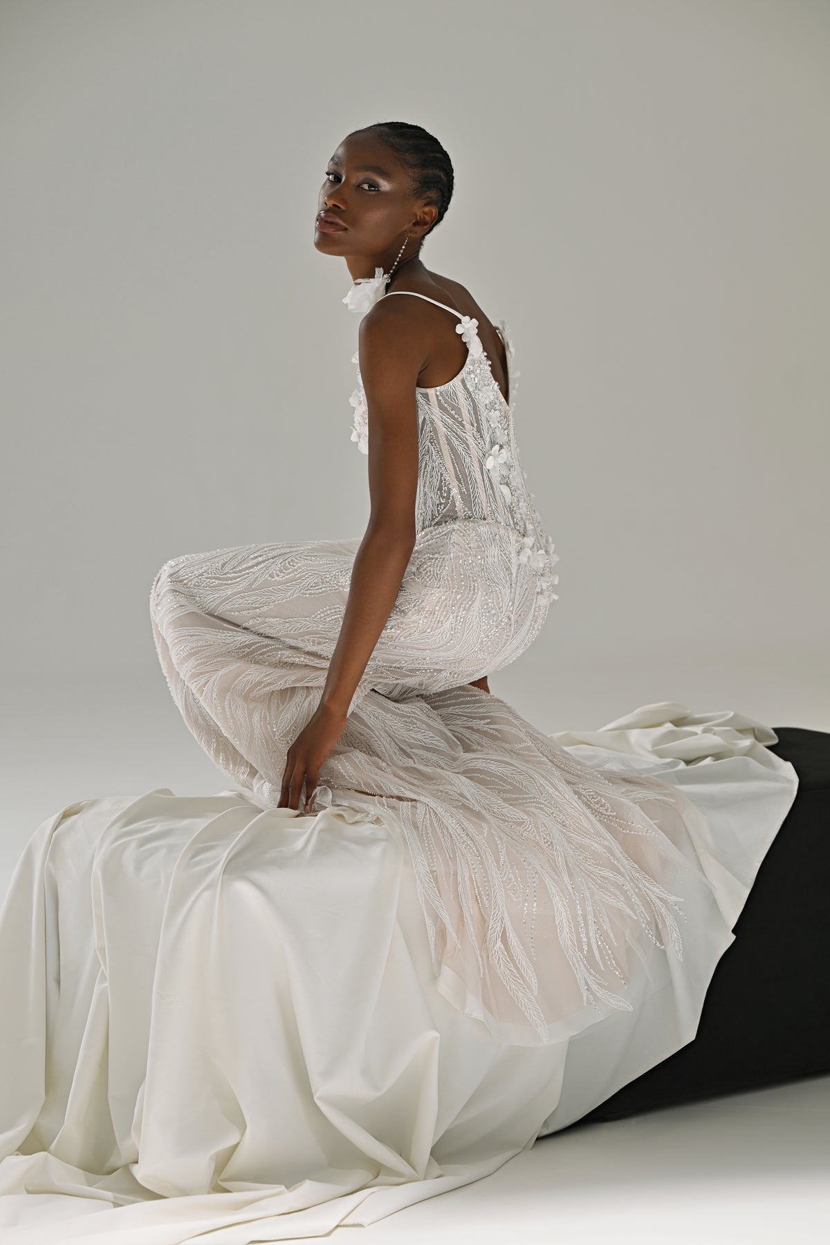 Lace mermaid wedding dress – side view seated on the block with the fringe-trimmed skirt