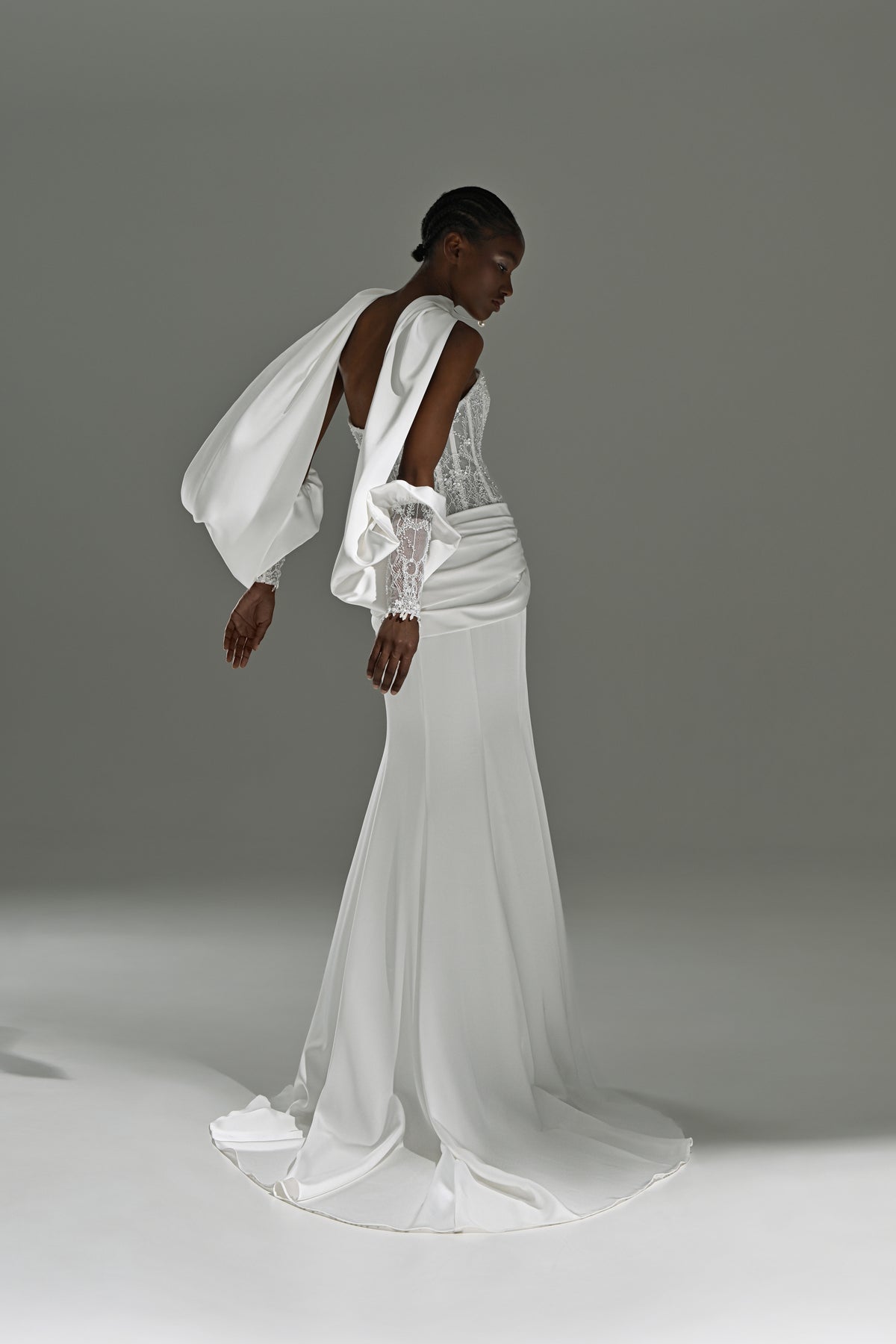 Satin sheath wedding dress with draped hip – side view leaning forward
