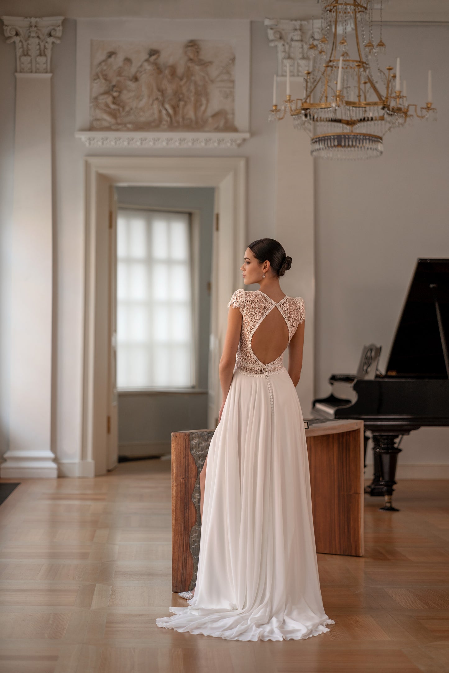 Modest chiffon wedding dress featuring an open diamond-shaped back and slit skirt.