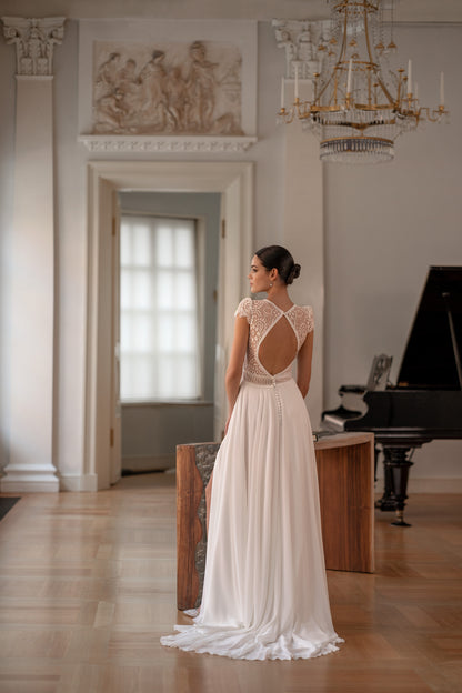 Sleeveless chiffon A-line wedding dress with lace details.