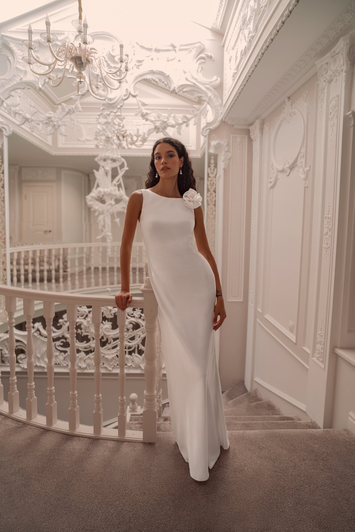 Minimalist silk wedding gown with sculpted rose shoulder and open back.