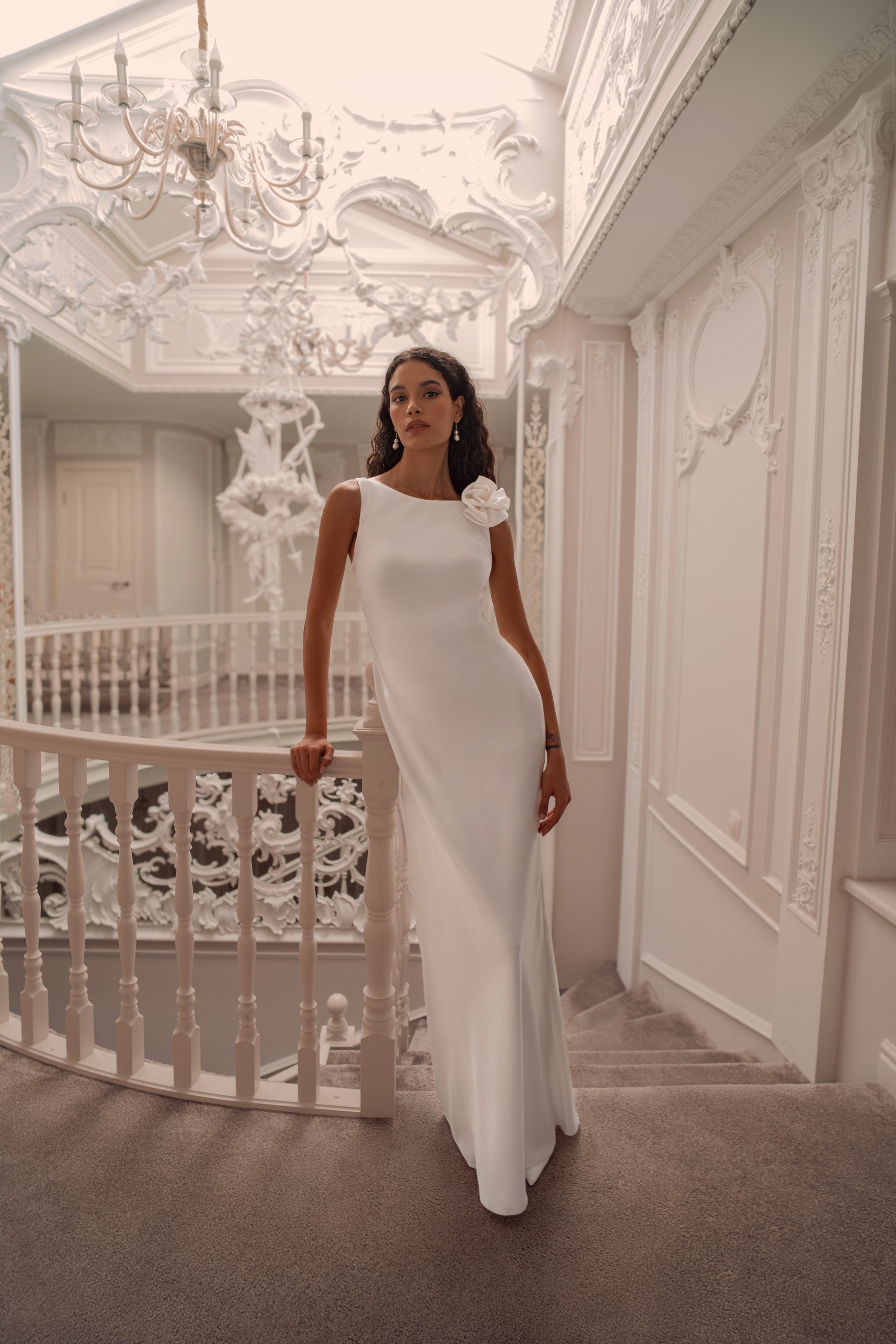 Minimalist silk wedding gown with sculpted rose shoulder and open back.