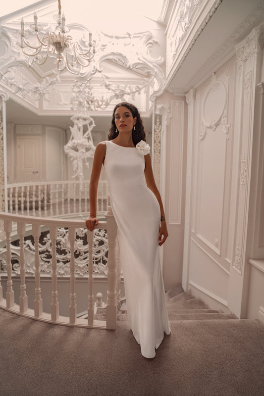 Minimalist silk wedding gown with sculpted rose shoulder and open back.