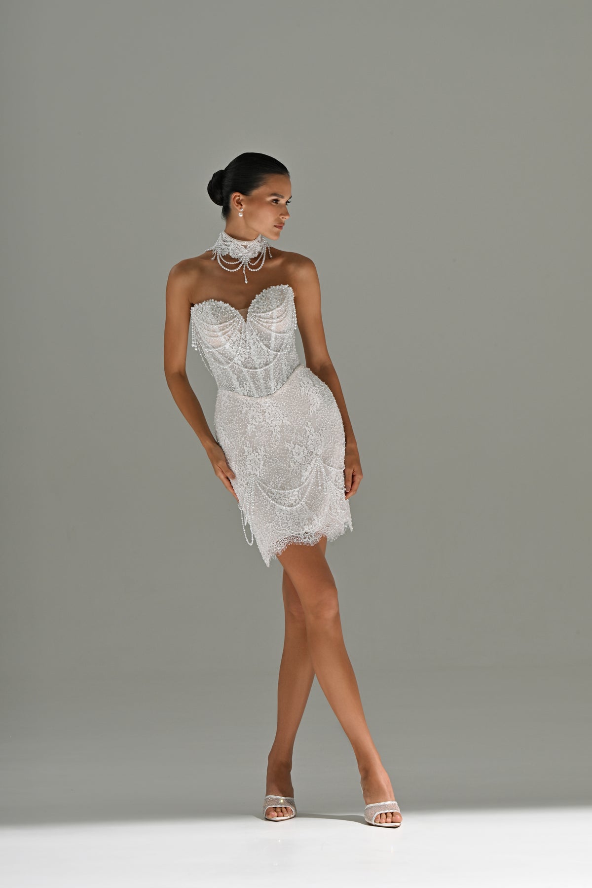 Lace mini wedding dress with sweetheart corset – full-length front view, legs crossed
