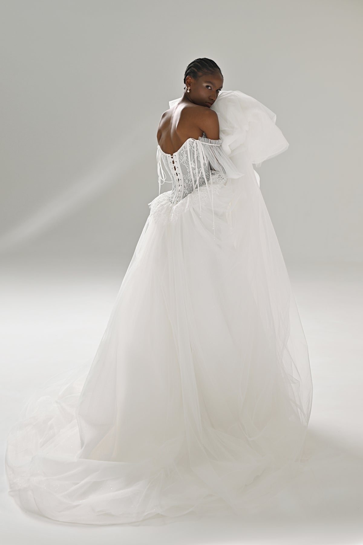 Lace and tulle ball gown wedding dress with puff sleeves – back three-quarter view of the tulle skirt