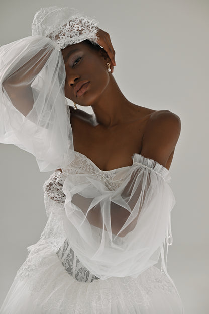 Lace and tulle ball gown wedding dress – close-up of the corset with sheer sleeve raised to the head