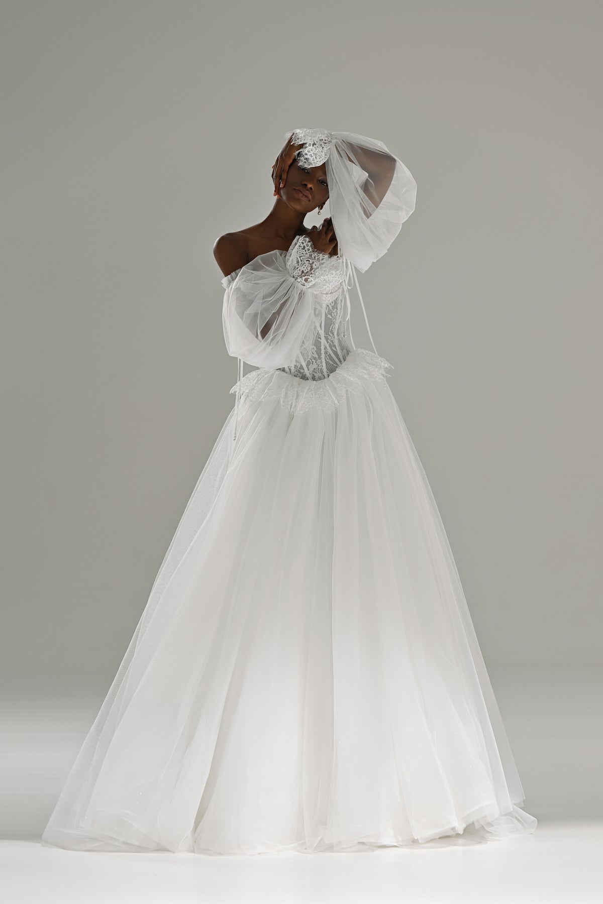 Lace and tulle ball gown wedding dress with puff sleeves – full-length front view, arm raised