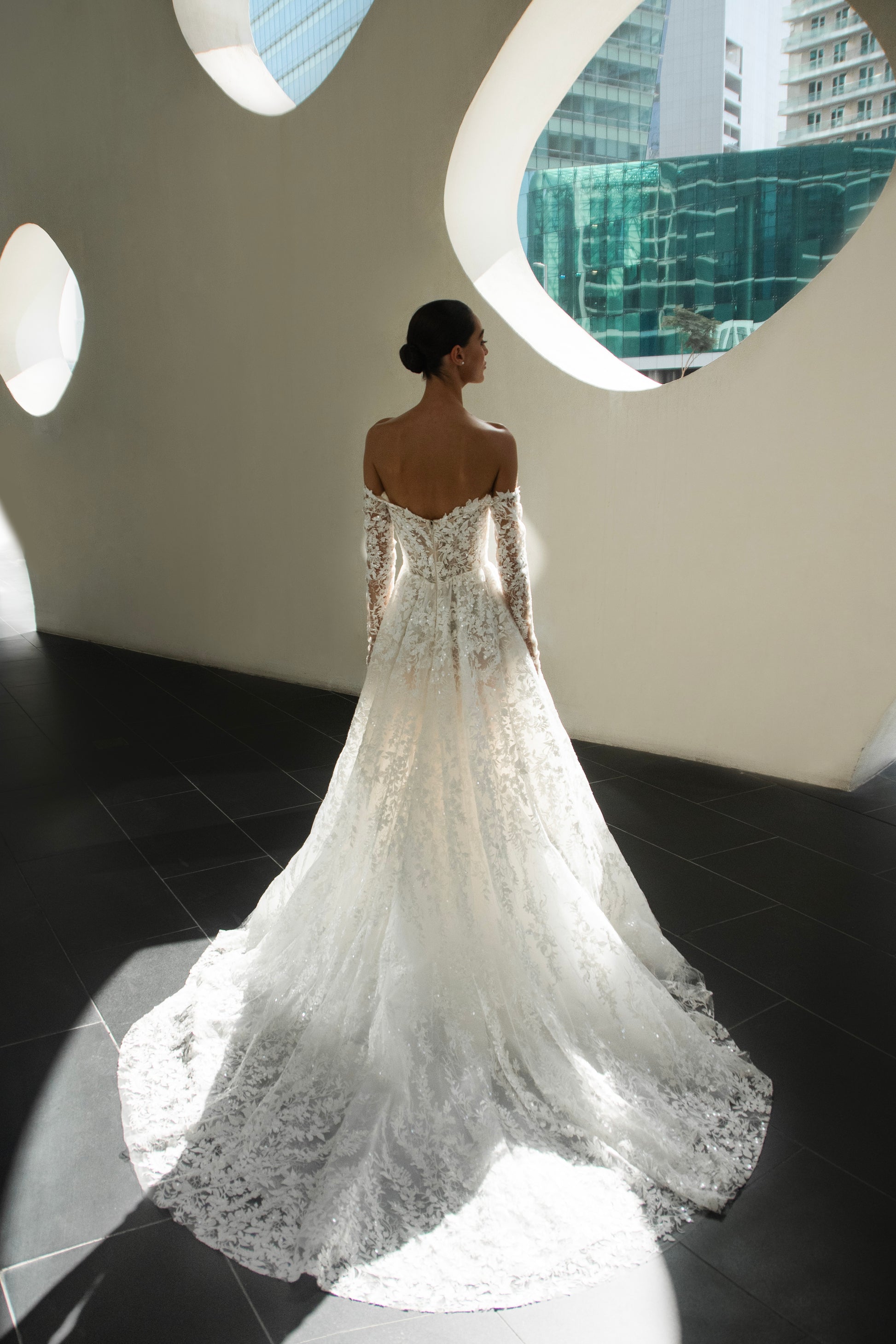 Celeste off-shoulder lace and tulle ball gown with detachable long sleeves and chapel train.