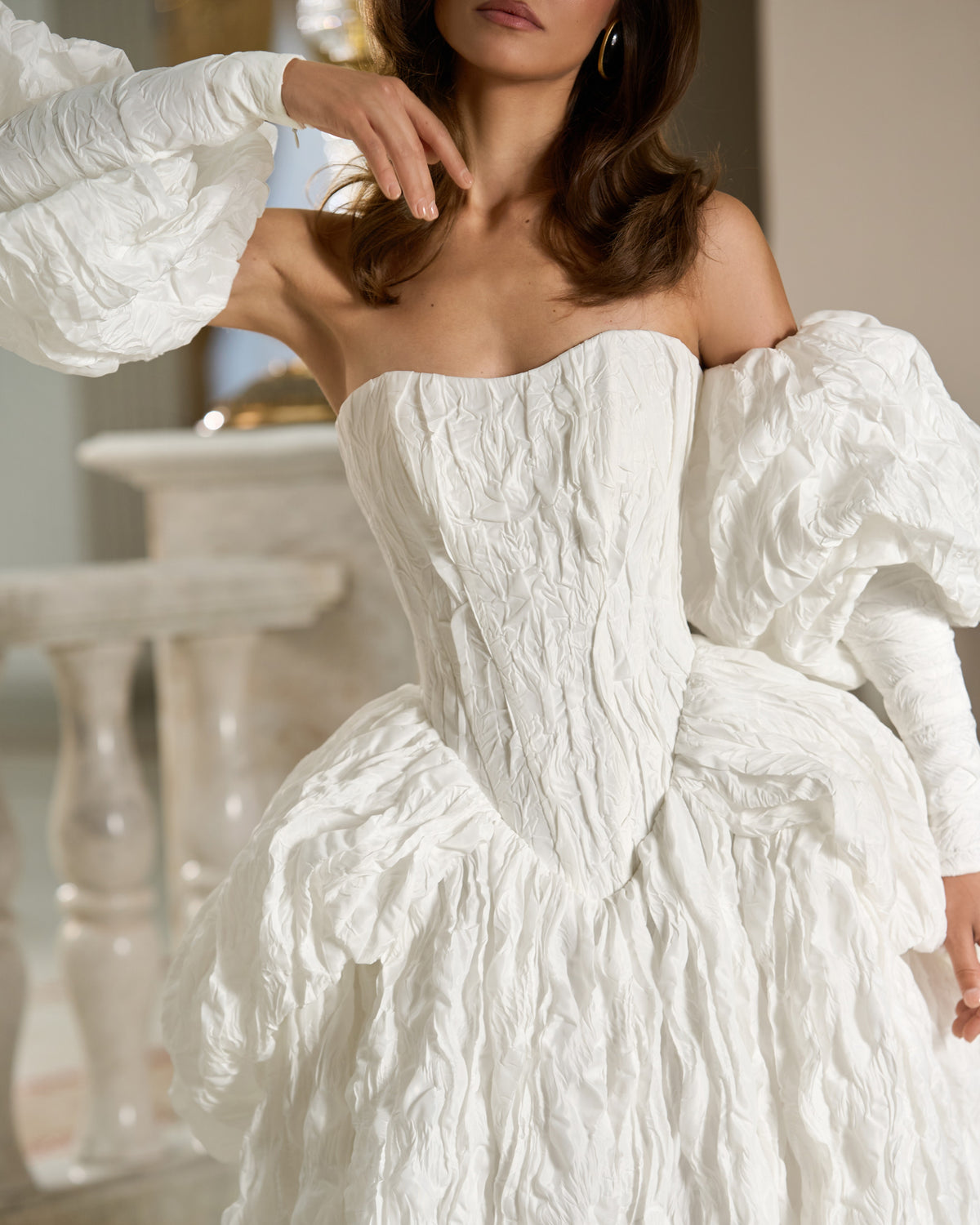 Close-up of the white taffeta sweetheart bodice and off-the-shoulder puff sleeves with a crinkled texture.