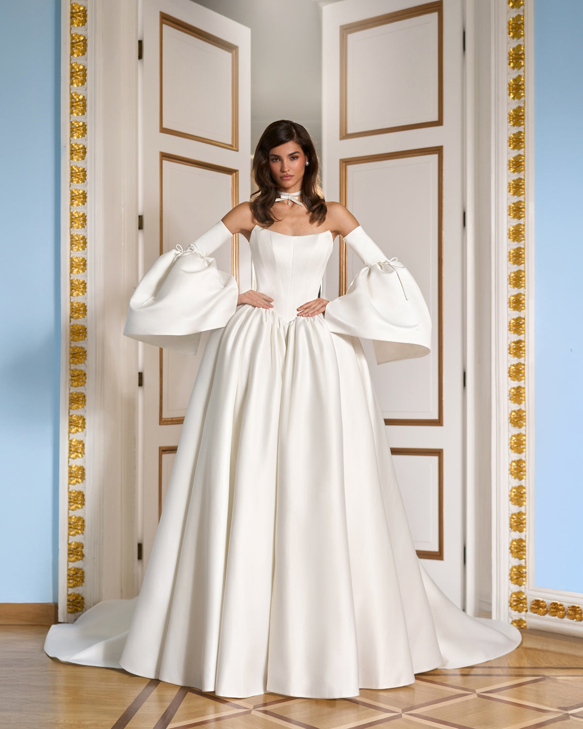 Front view of an ivory basque waist wedding dress with a structured bodice, full skirt and detachable bell sleeves.
