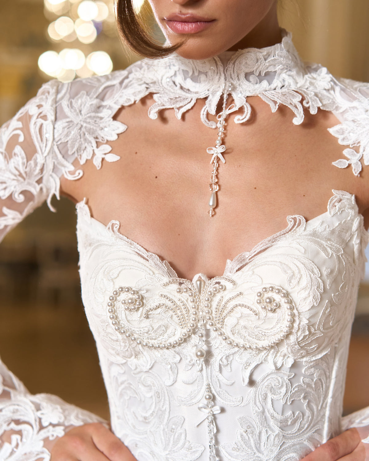 Close view of pearl-beaded sweetheart corset bodice, high-collar lace bolero and pearl pendant