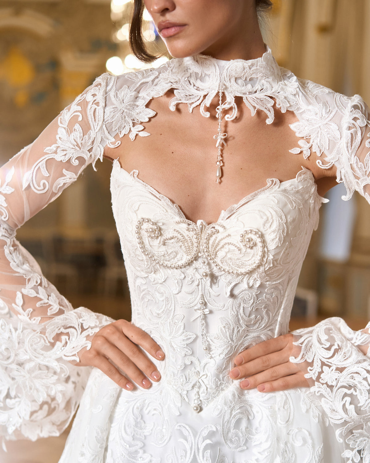Close view of lace bolero with bell sleeves over a pearl-beaded corset bodice