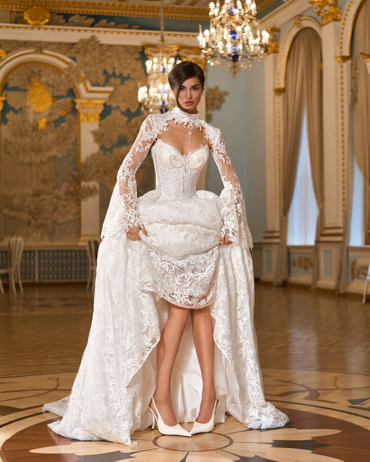 A-line lace ball gown skirt lifted to show the layered lace, with pearl corset bodice and lace bolero