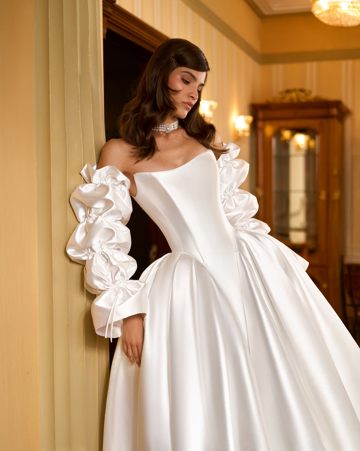 Close view of corset bodice, shaped hip pleats and detachable gathered satin sleeves