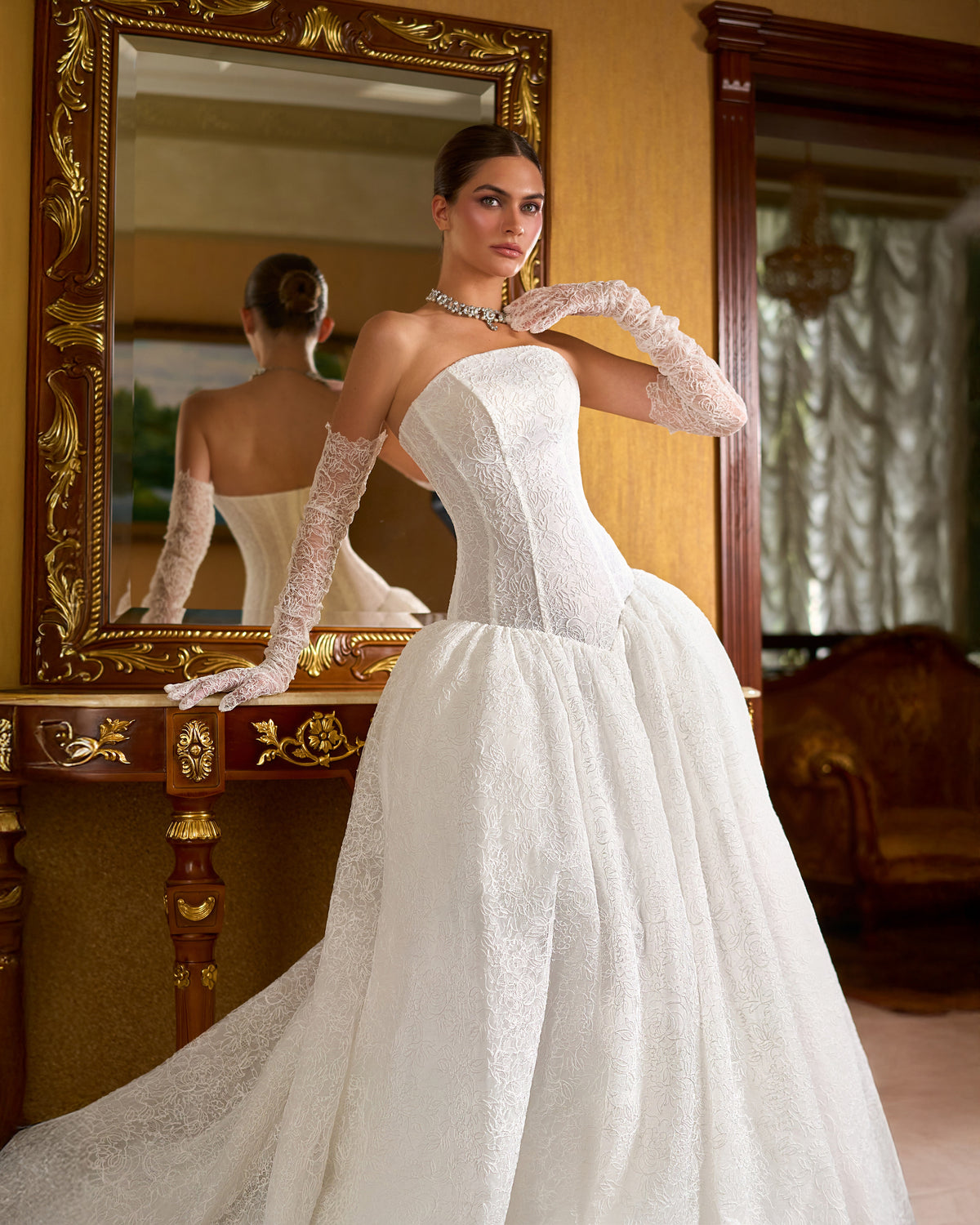 Close view of strapless lace corset bodice, drop waist and sheer lace glove on a ball gown