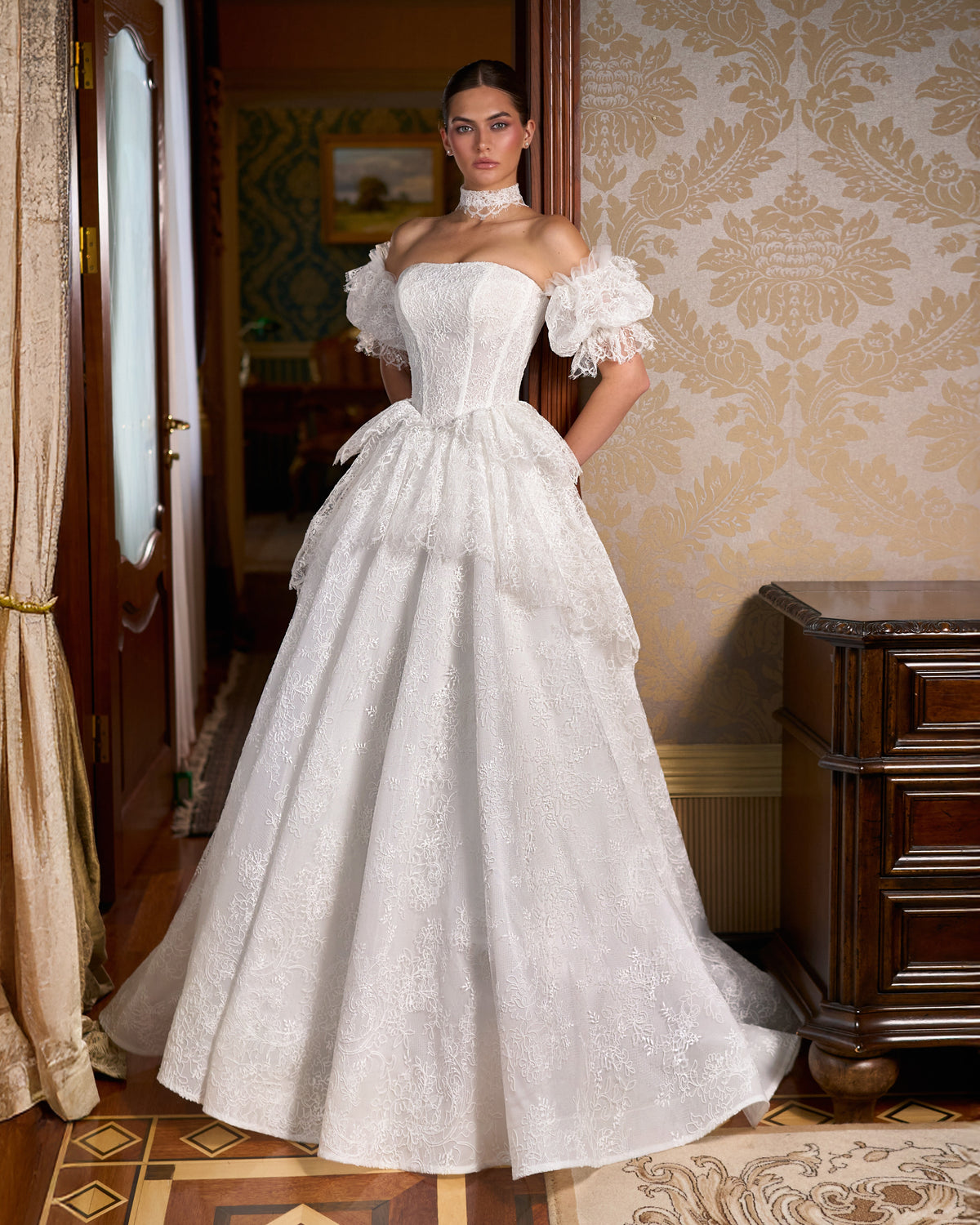 A-line lace wedding dress with strapless corset bodice, puff sleeves, peplum and full skirt