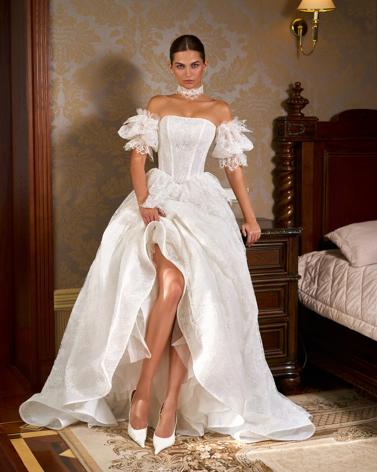 A-line lace wedding dress with corset bodice and puff sleeves, skirt lifted to show tulle underlayer