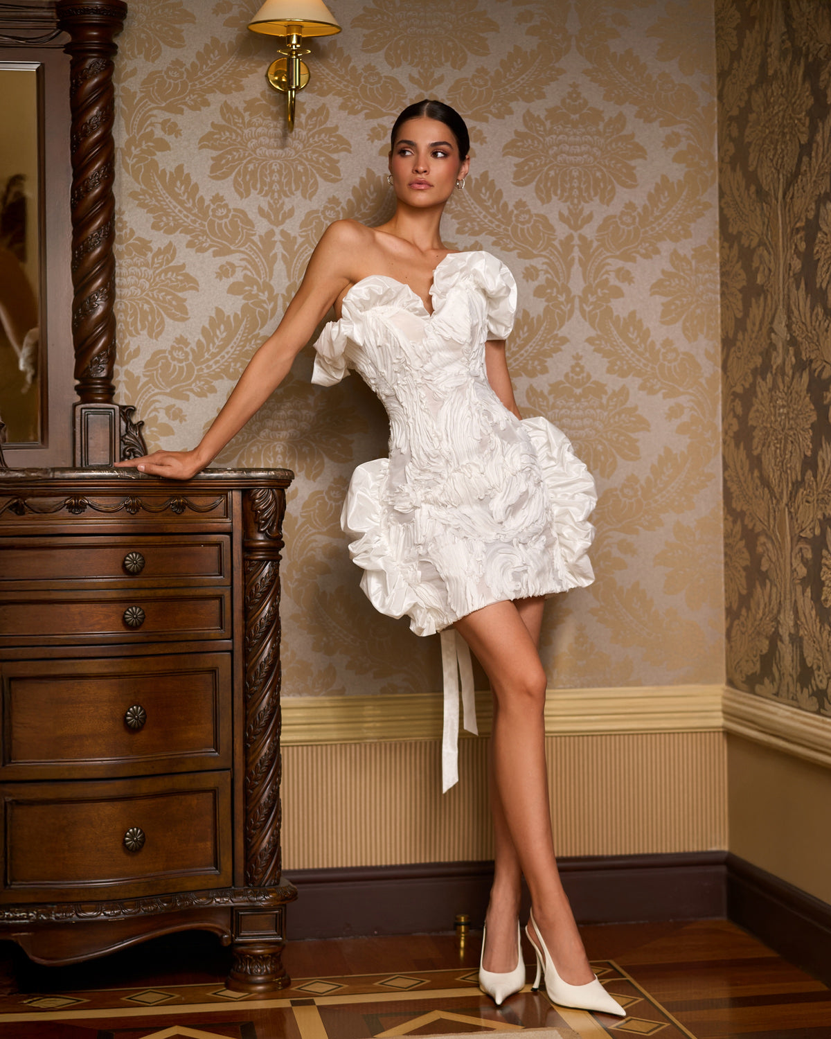 Mini wedding dress with a sweetheart neckline, off-the-shoulder ruffles and a short fitted skirt.
