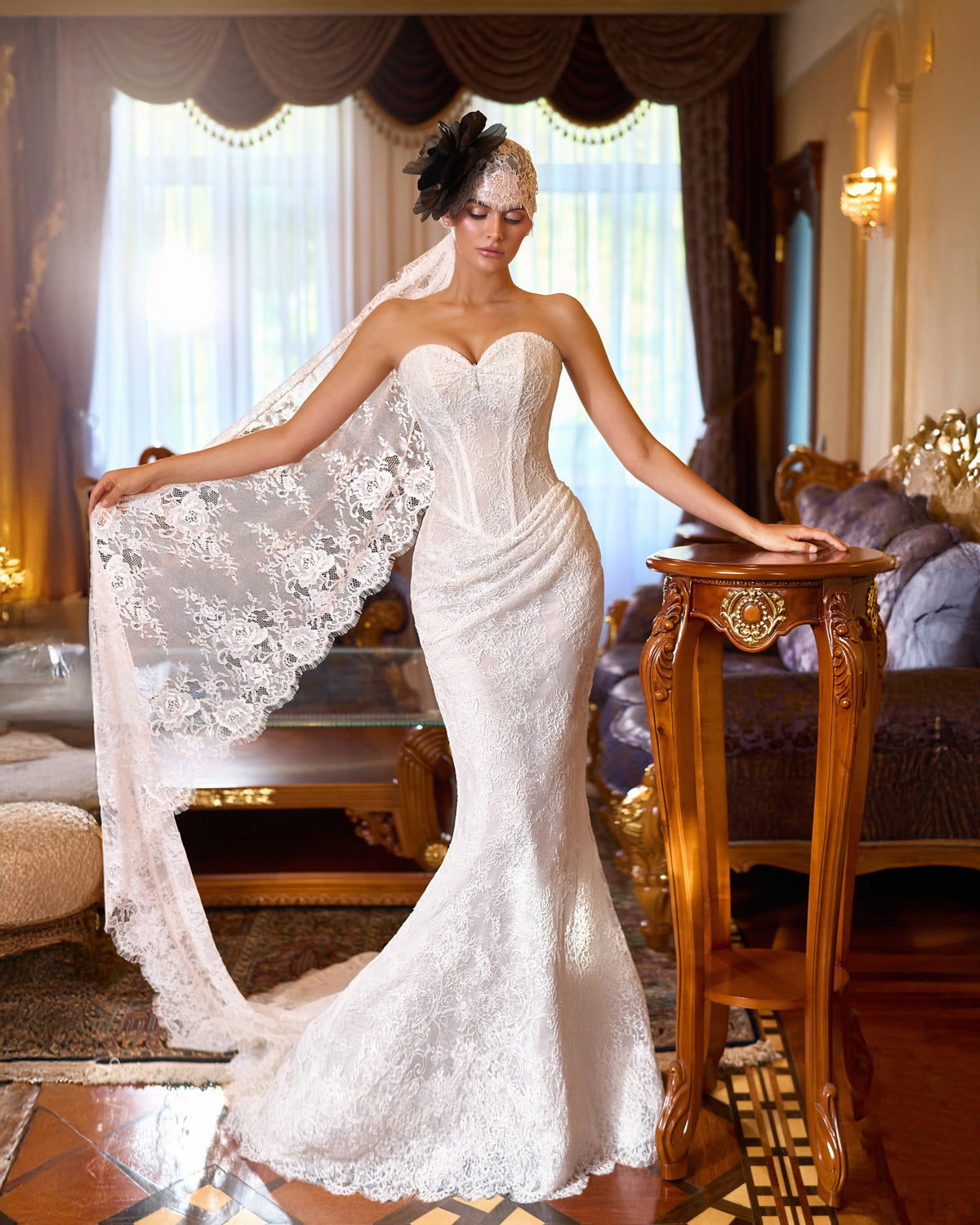 Mermaid wedding dress with floral lace, a sweetheart corset, draped hips and a lace bandana with a dark flower.