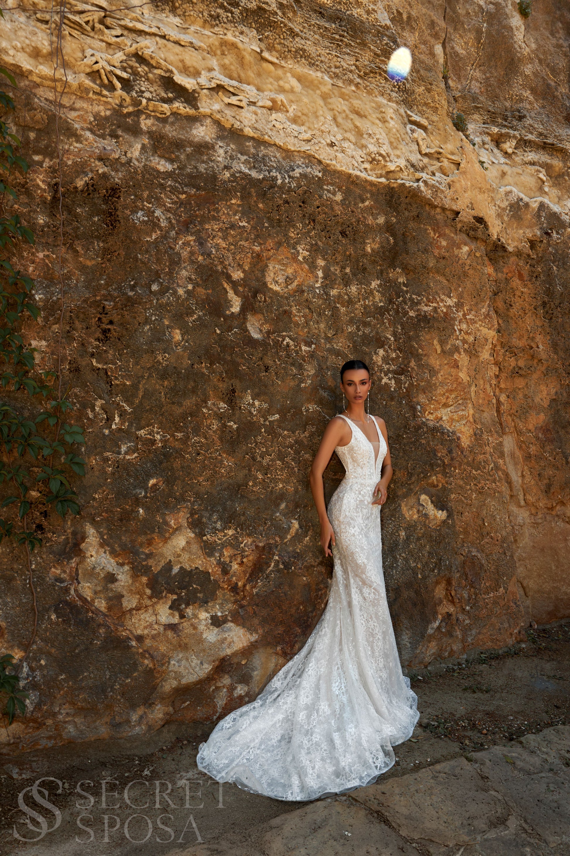 Bride in mermaid sequin embroidered lace wedding gown with deep-V neckline, open keyhole back, and sweep train.