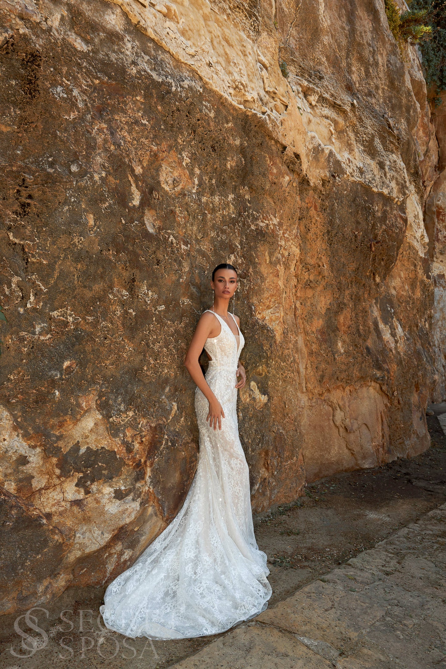 Bride in mermaid sequin embroidered lace wedding gown with deep-V neckline, open keyhole back, and sweep train.