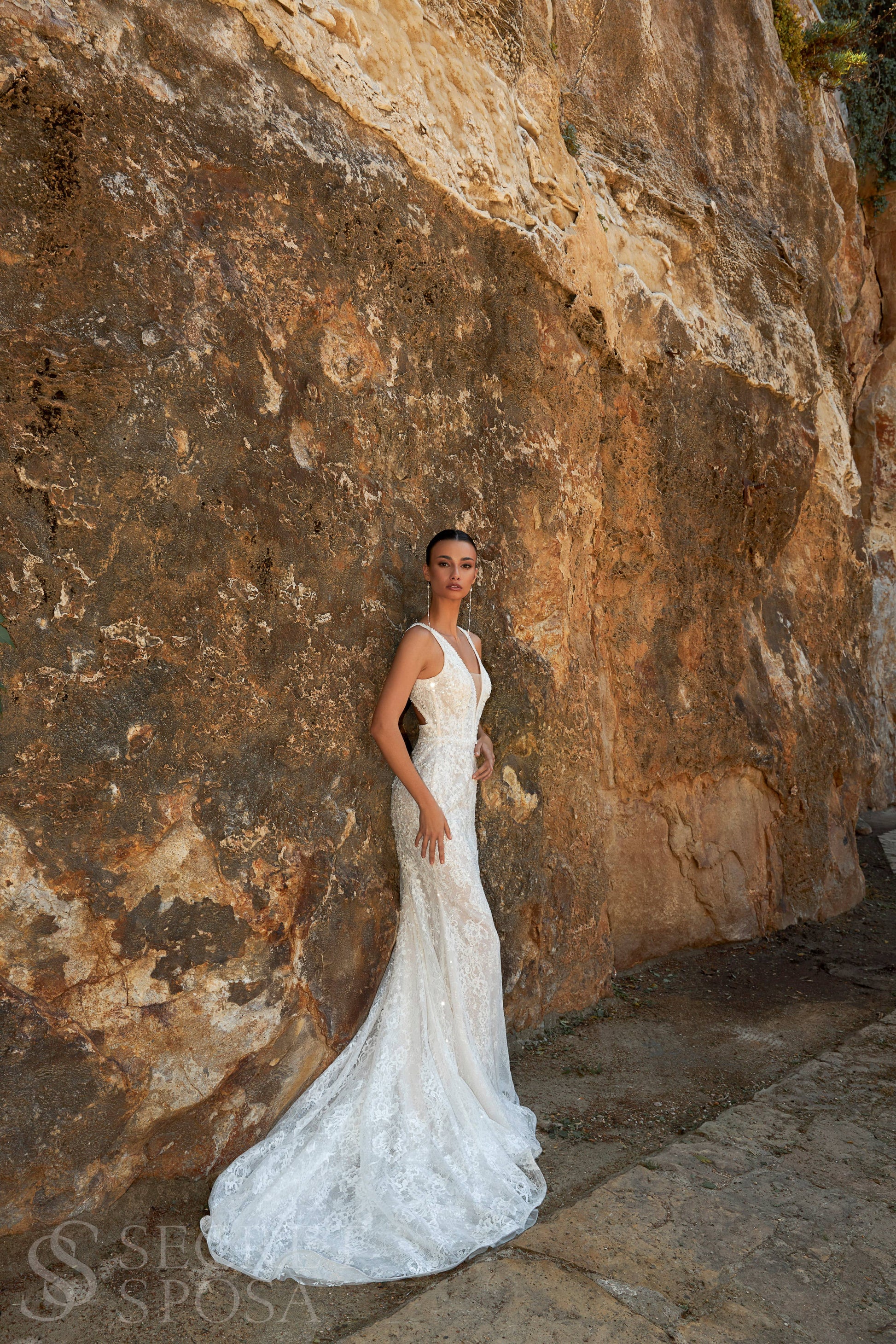 Bride in mermaid sequin embroidered lace wedding gown with deep-V neckline, open keyhole back, and sweep train.