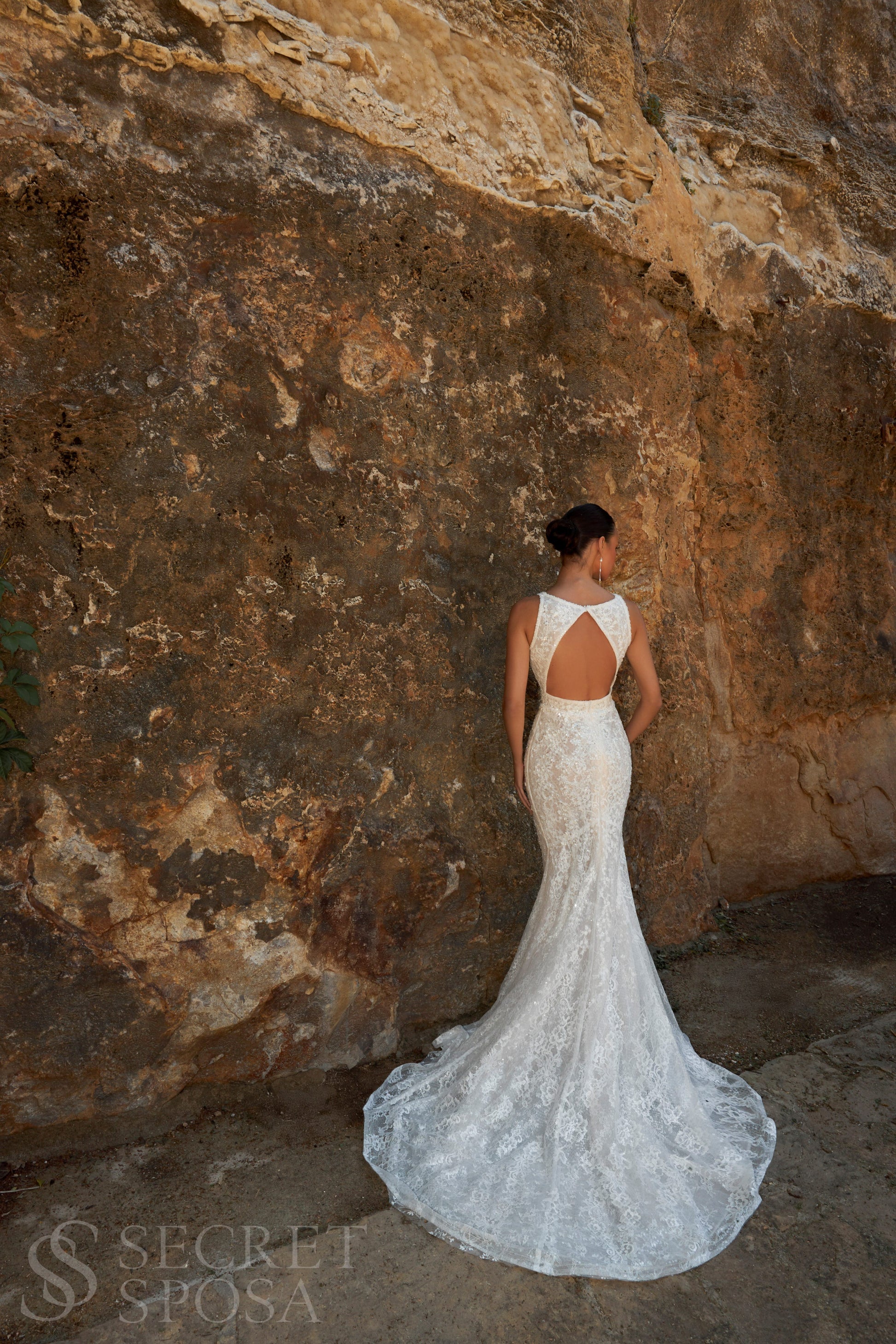 Bride in mermaid sequin embroidered lace wedding gown with deep-V neckline, open keyhole back, and sweep train.