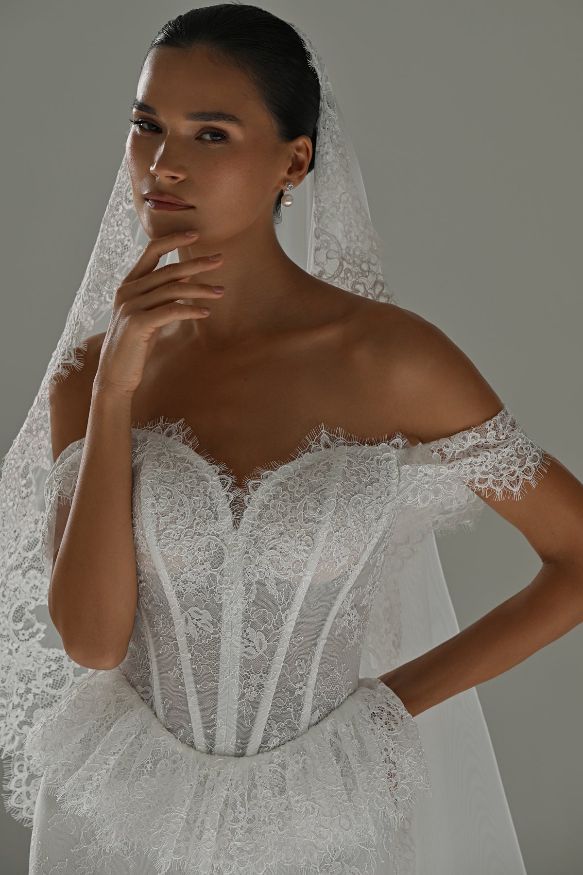 Lace mermaid wedding dress with off-shoulder corset – close-up of the corset, cap sleeves and lace veil