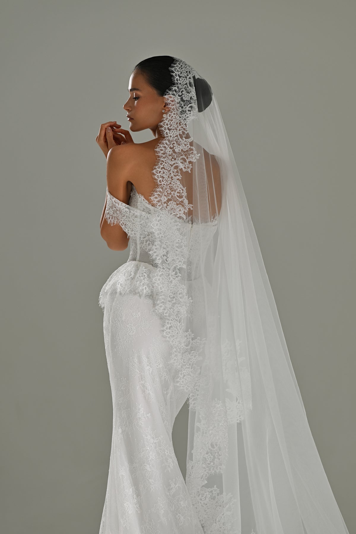 Lace mermaid wedding dress with cap sleeves – side three-quarter view with the lace-edged veil and hip slit