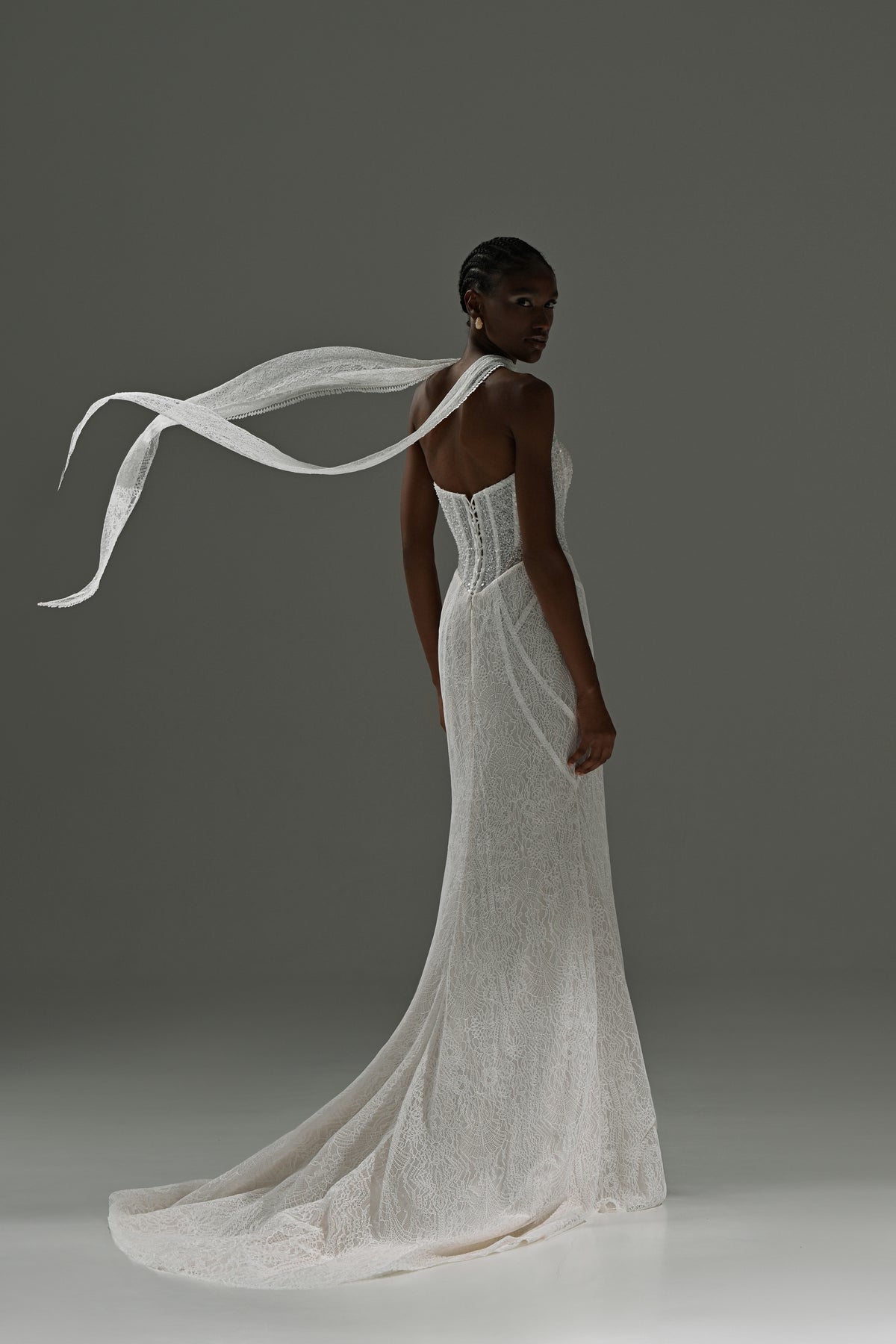 Lace mermaid wedding dress with scarf collar – back view with the scarf flying and the train on the floor