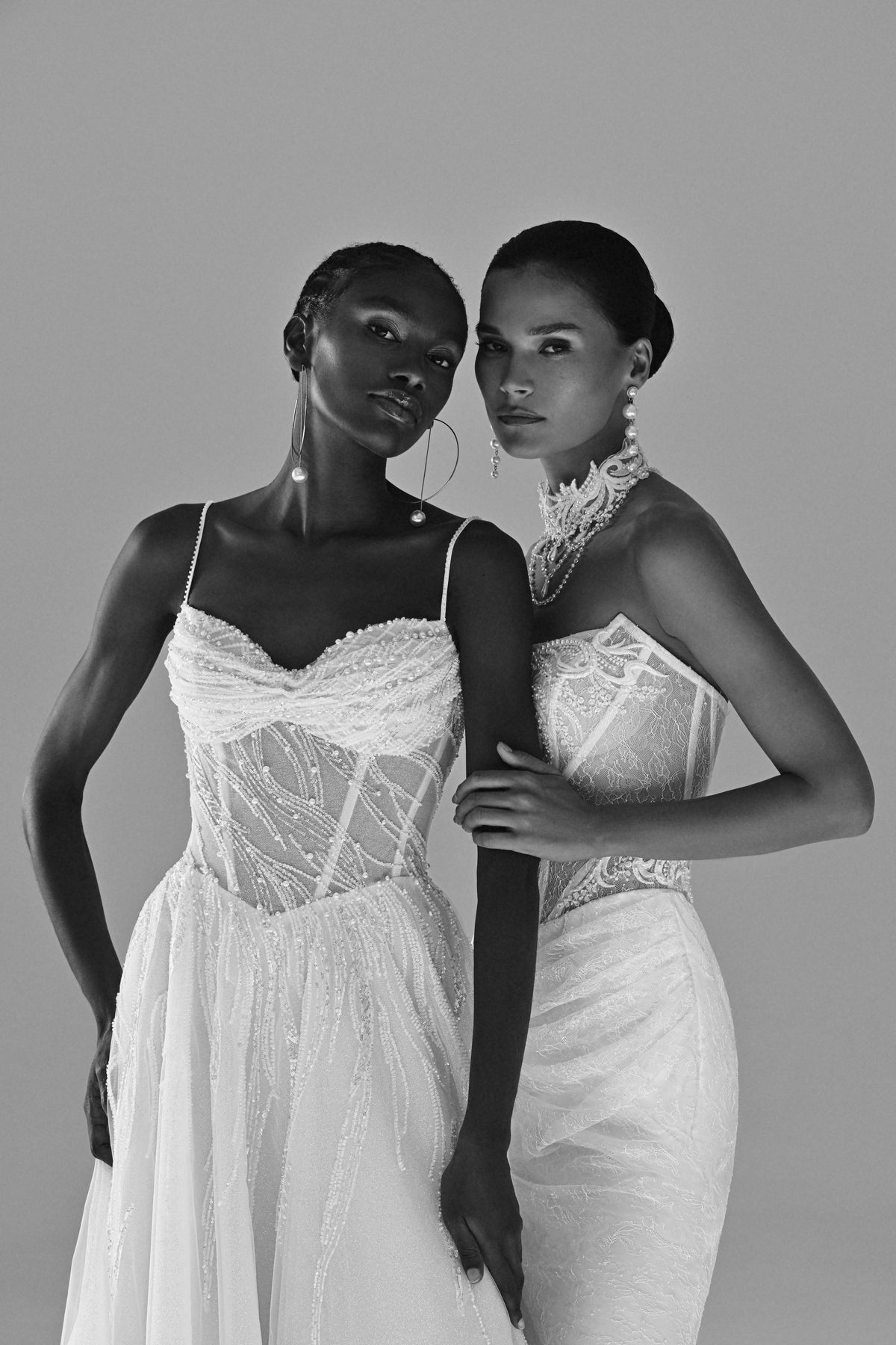 Tulle A-line wedding dress with lace corset – black and white close view of two brides