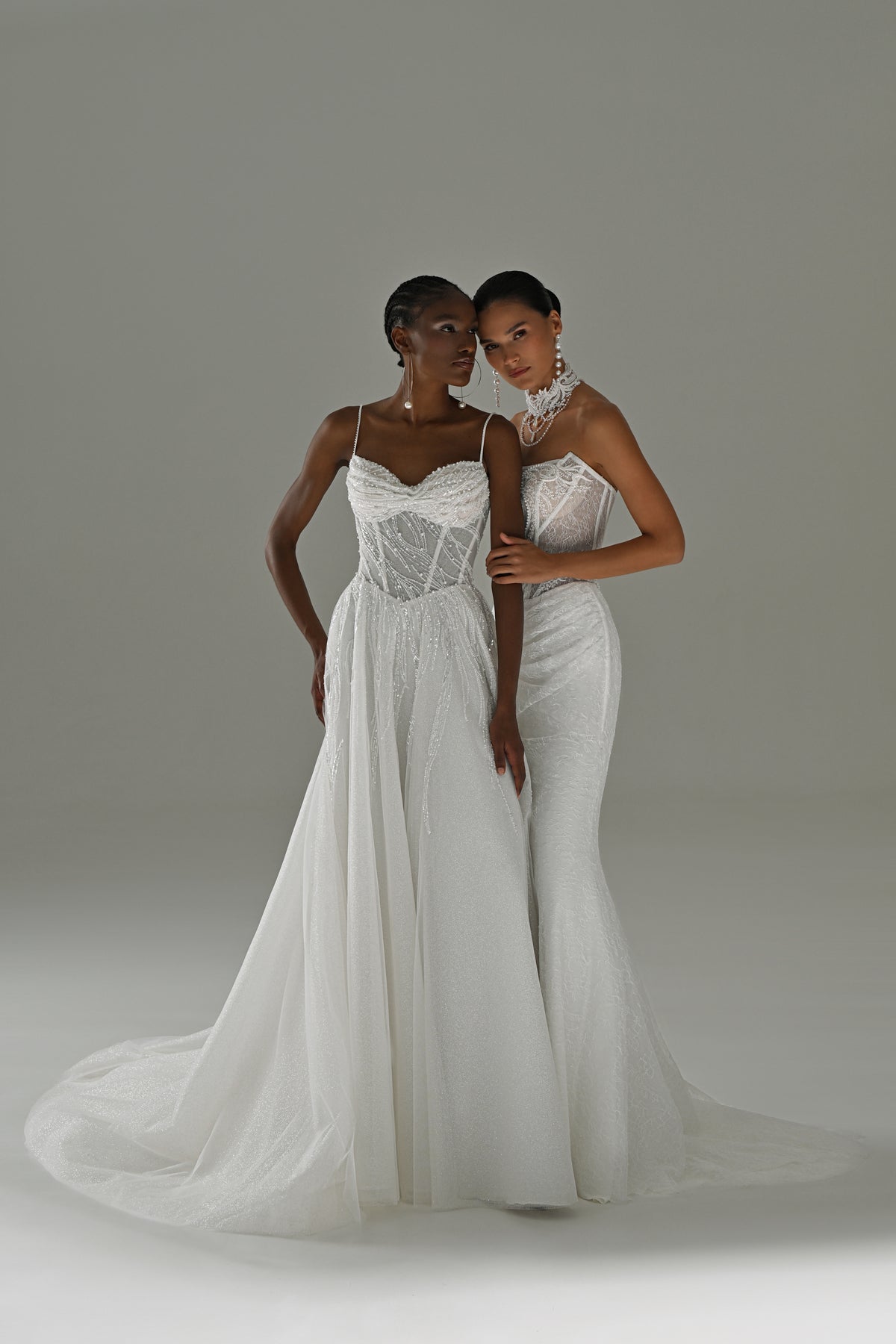 Tulle A-line wedding dress with lace corset and spaghetti straps – two brides standing, full-length view