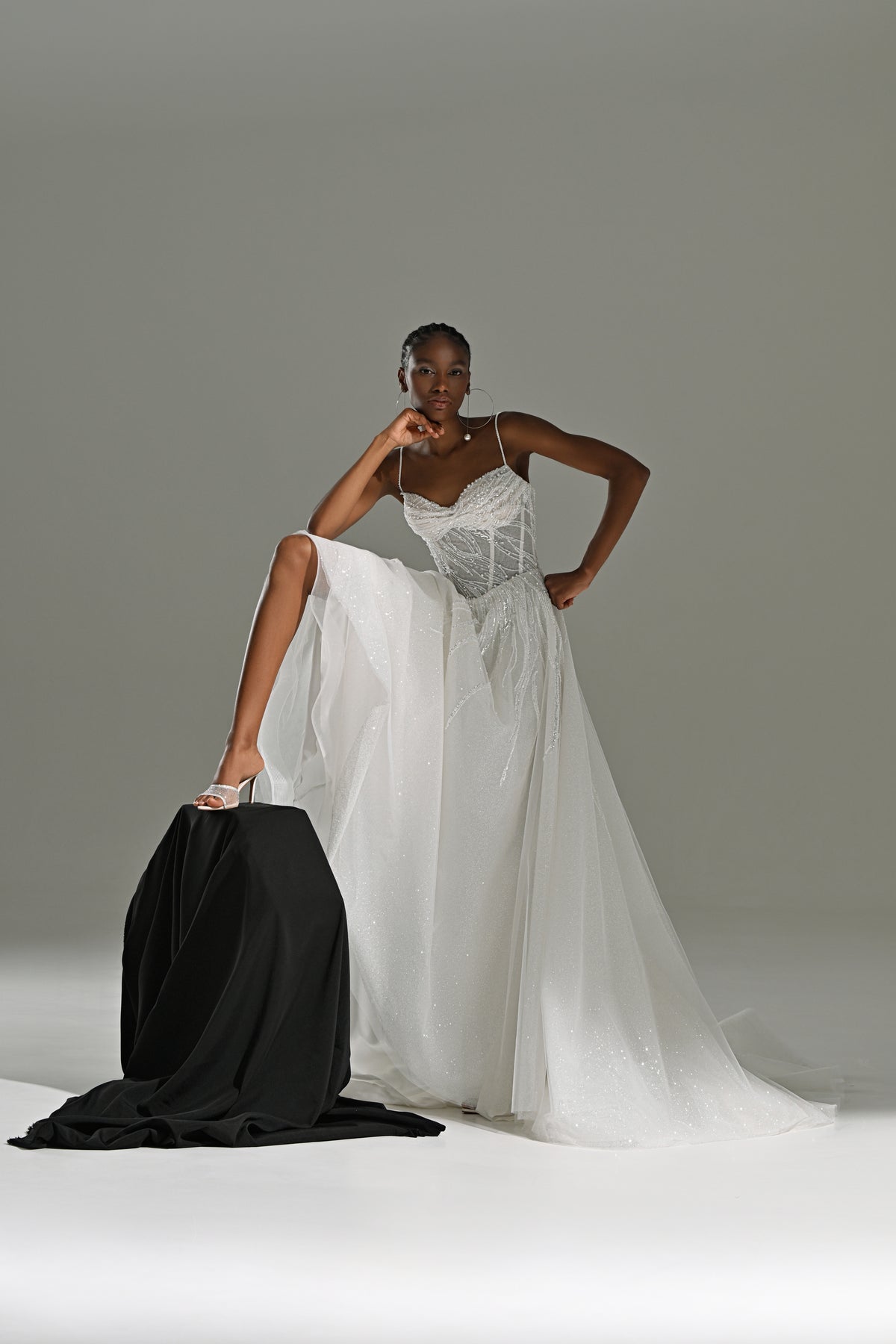 Tulle A-line wedding dress with lace corset – model posing beside a black fabric drape