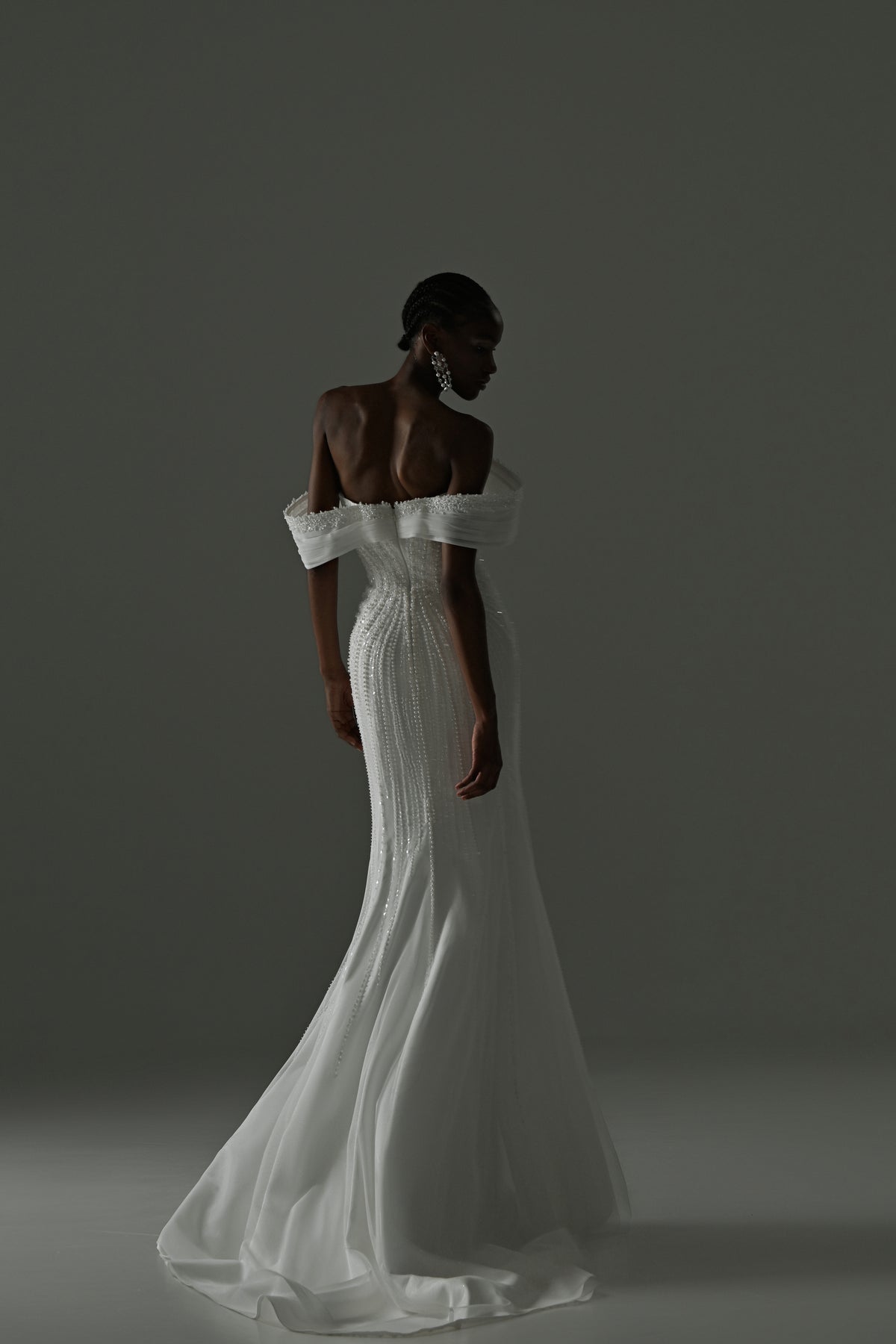 Lace mermaid wedding dress with off-shoulder neckline – back three-quarter view with the train