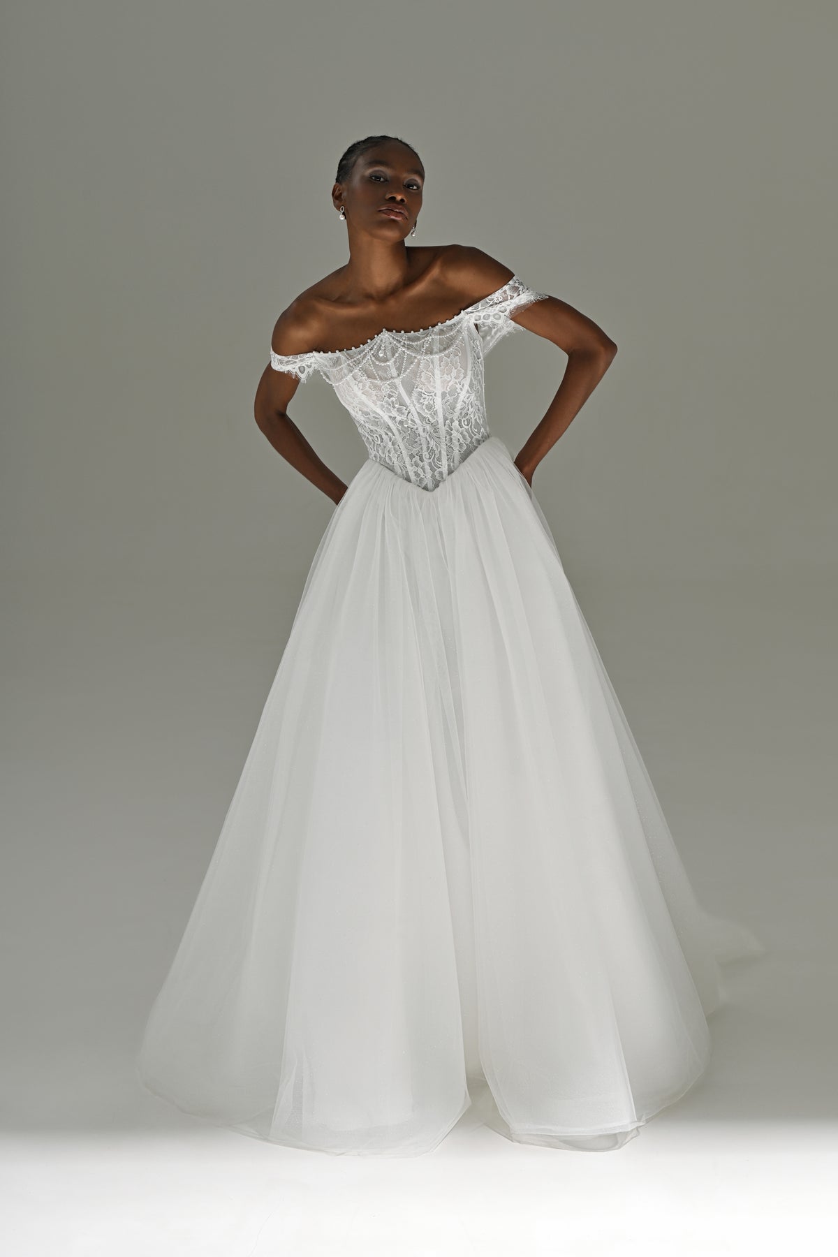 Tulle ball gown wedding dress with off-shoulder lace corset – full-length front view, hands on hips