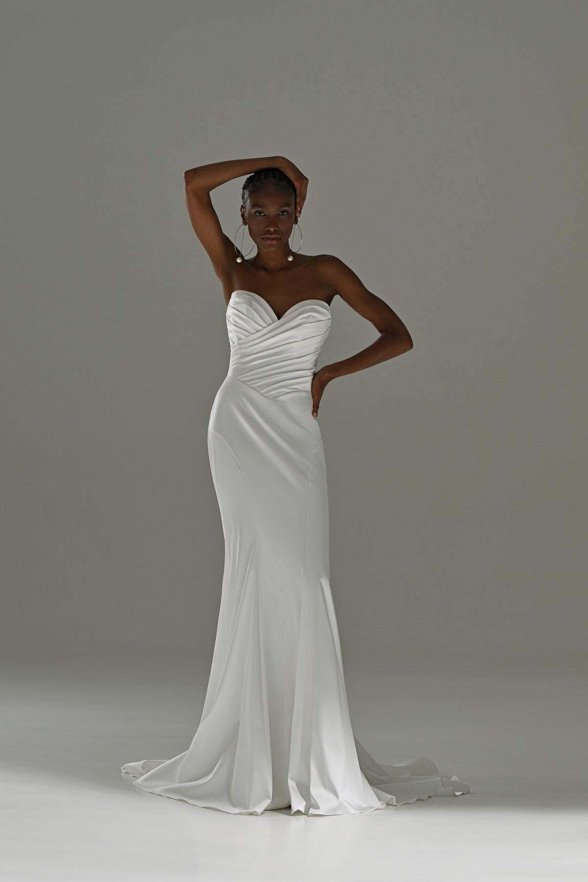 Stretch satin mermaid wedding dress with ruched sweetheart bodice – front view, hand at the head