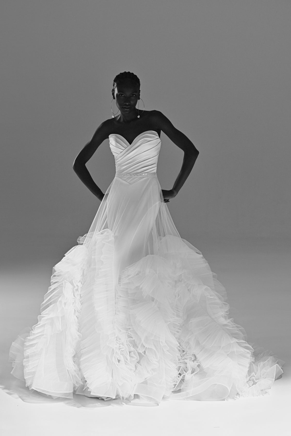 Stretch satin mermaid wedding dress with ruched sweetheart bodice – black and white front view, hands on hips