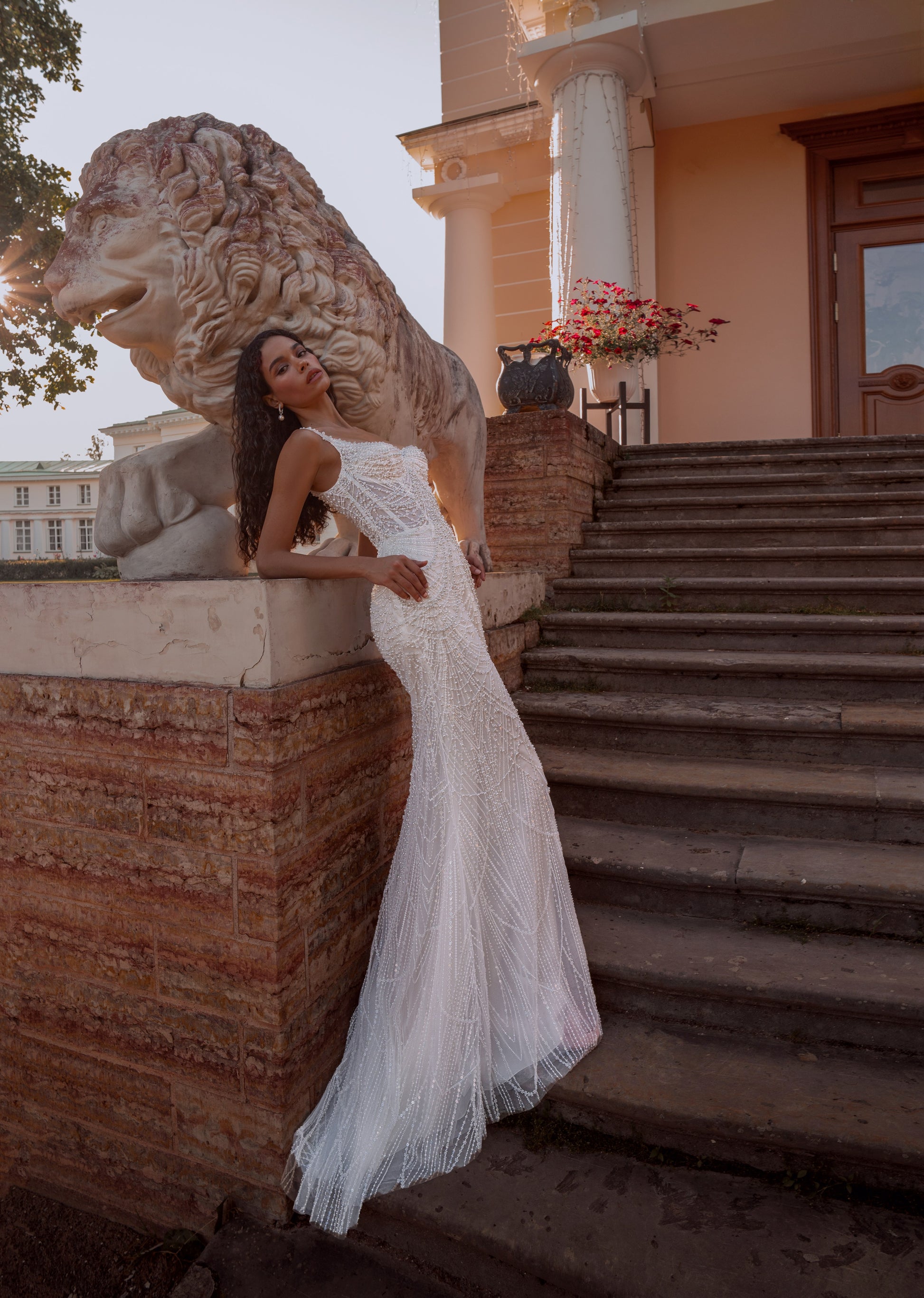 Beaded mermaid wedding gown with geometric pearl embroidery, sheer corset bodice, and elegant train.