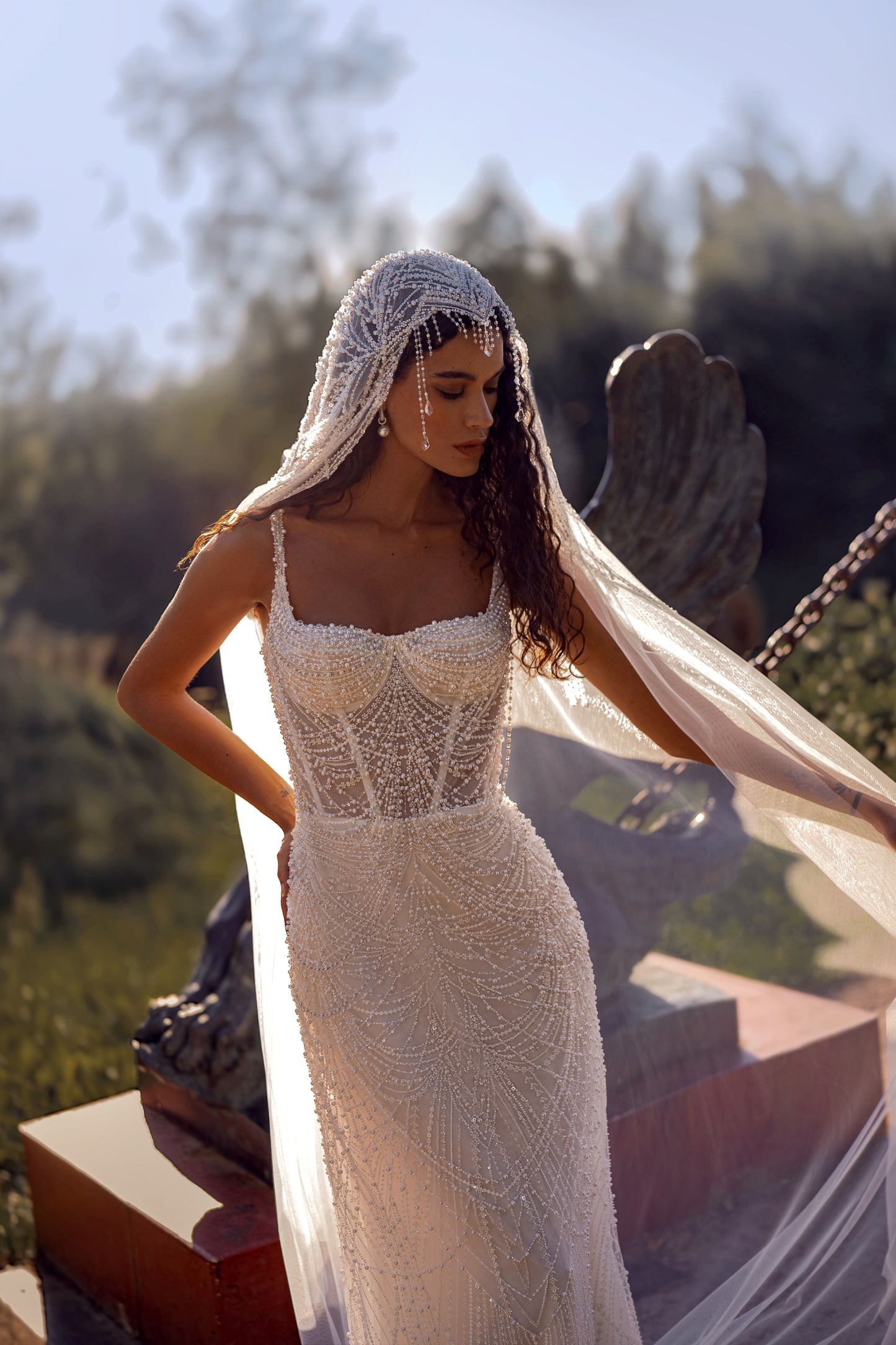 Beaded mermaid wedding gown with geometric pearl embroidery, sheer corset bodice, and elegant train.