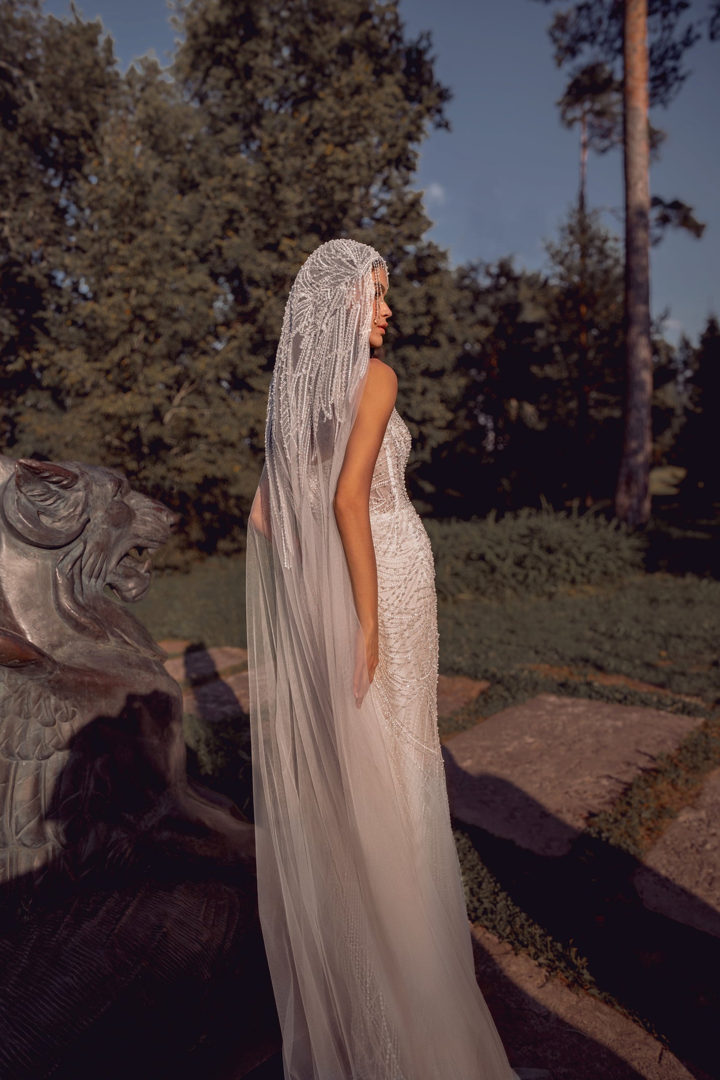 Beaded mermaid wedding gown with geometric pearl embroidery, sheer corset bodice, and elegant train.