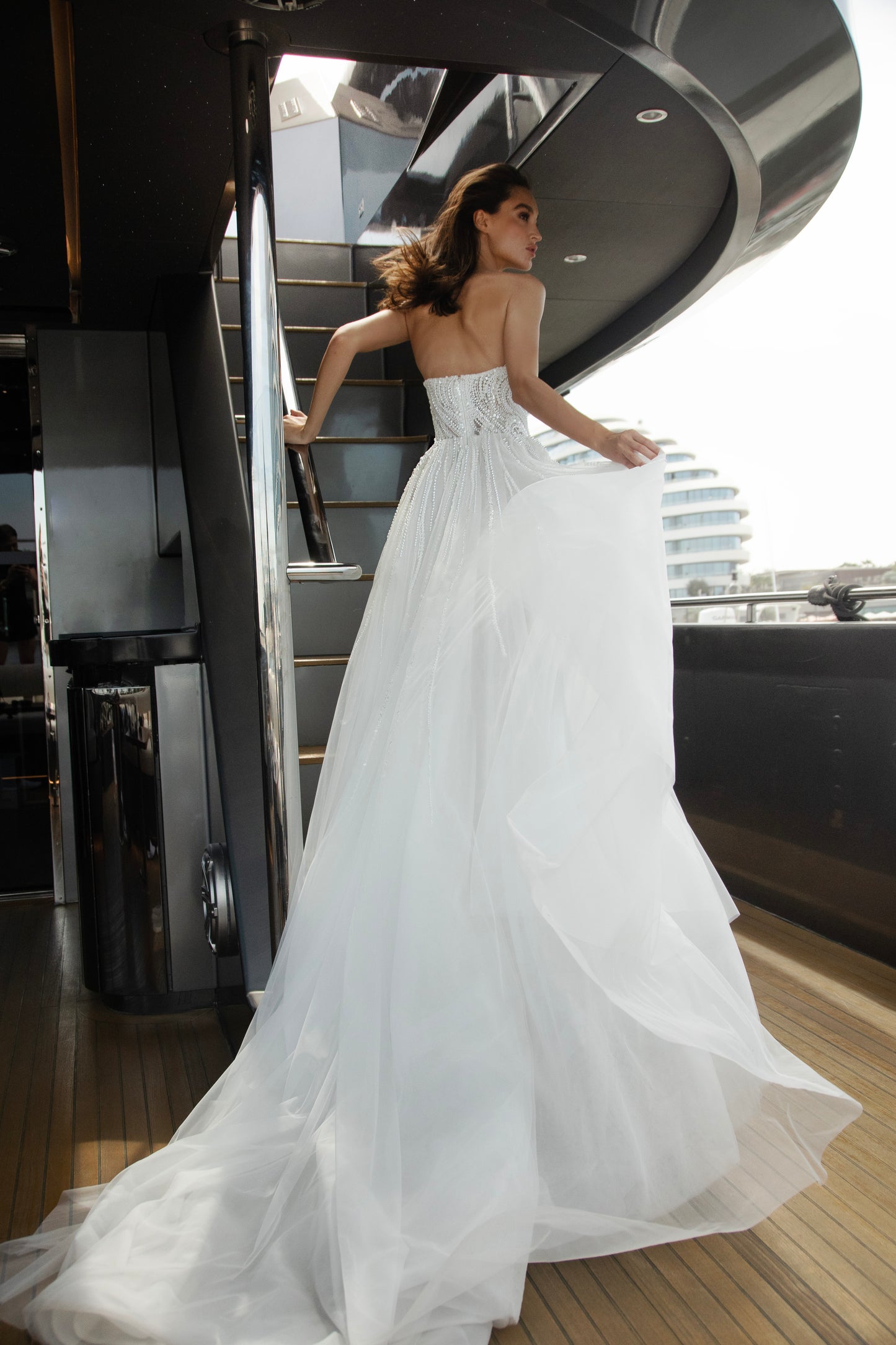 Bride wearing a beaded A-line wedding gown with sweetheart neckline and detachable illusion bolero featuring long sleeves and open back.